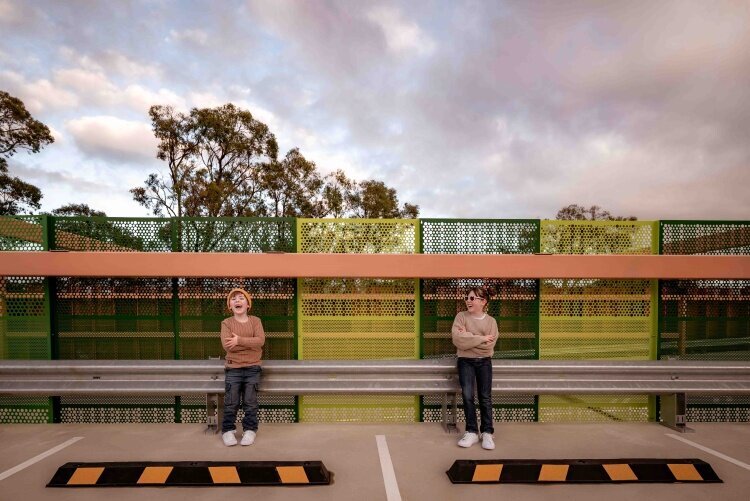 Siblings in jeans laughing at rooftop carpark by Melbourne Family Photographer Kate Cashin