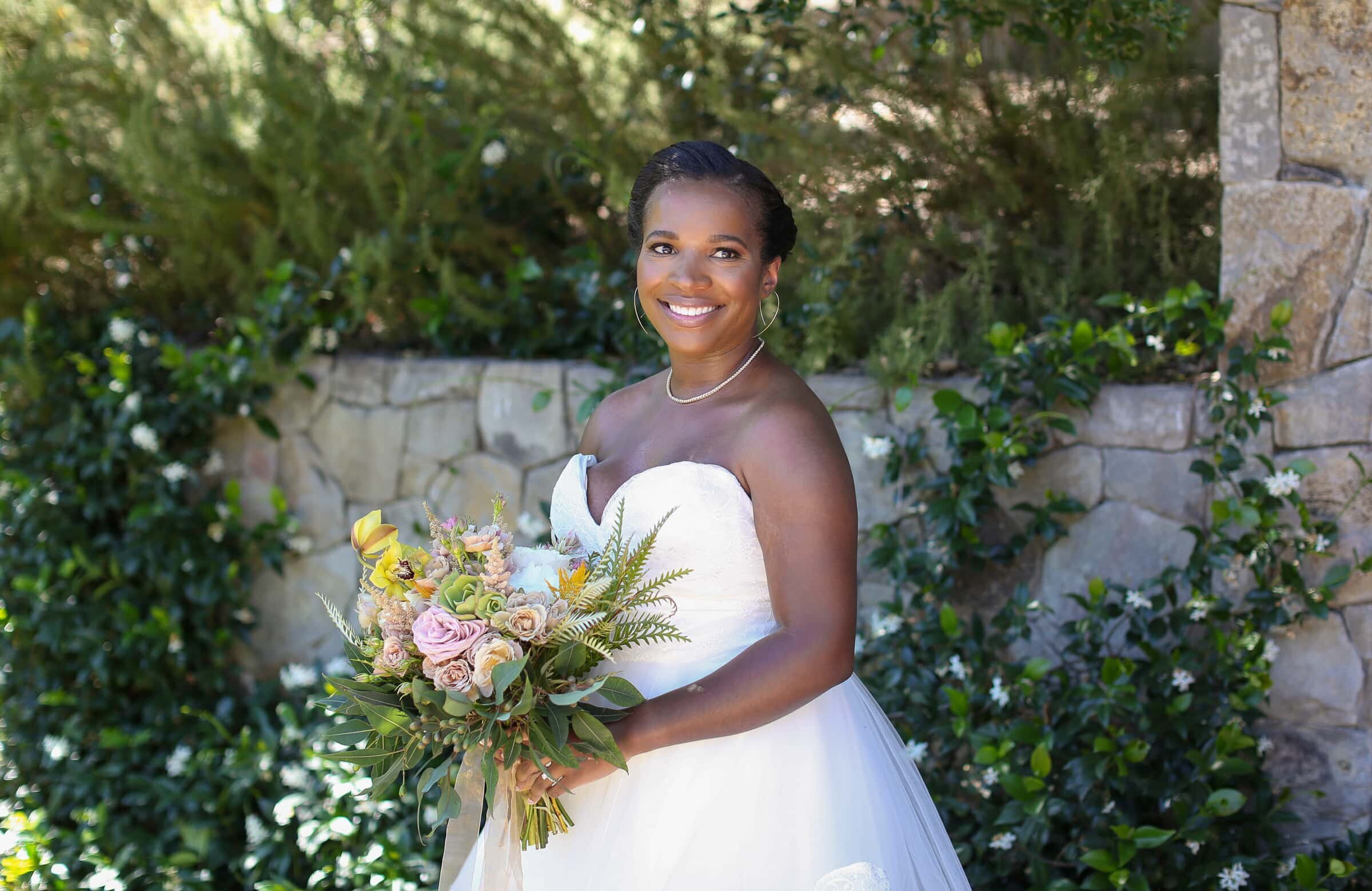 african-american bride holding pink and yellow bouquet  by Raleigh wedding photographer.