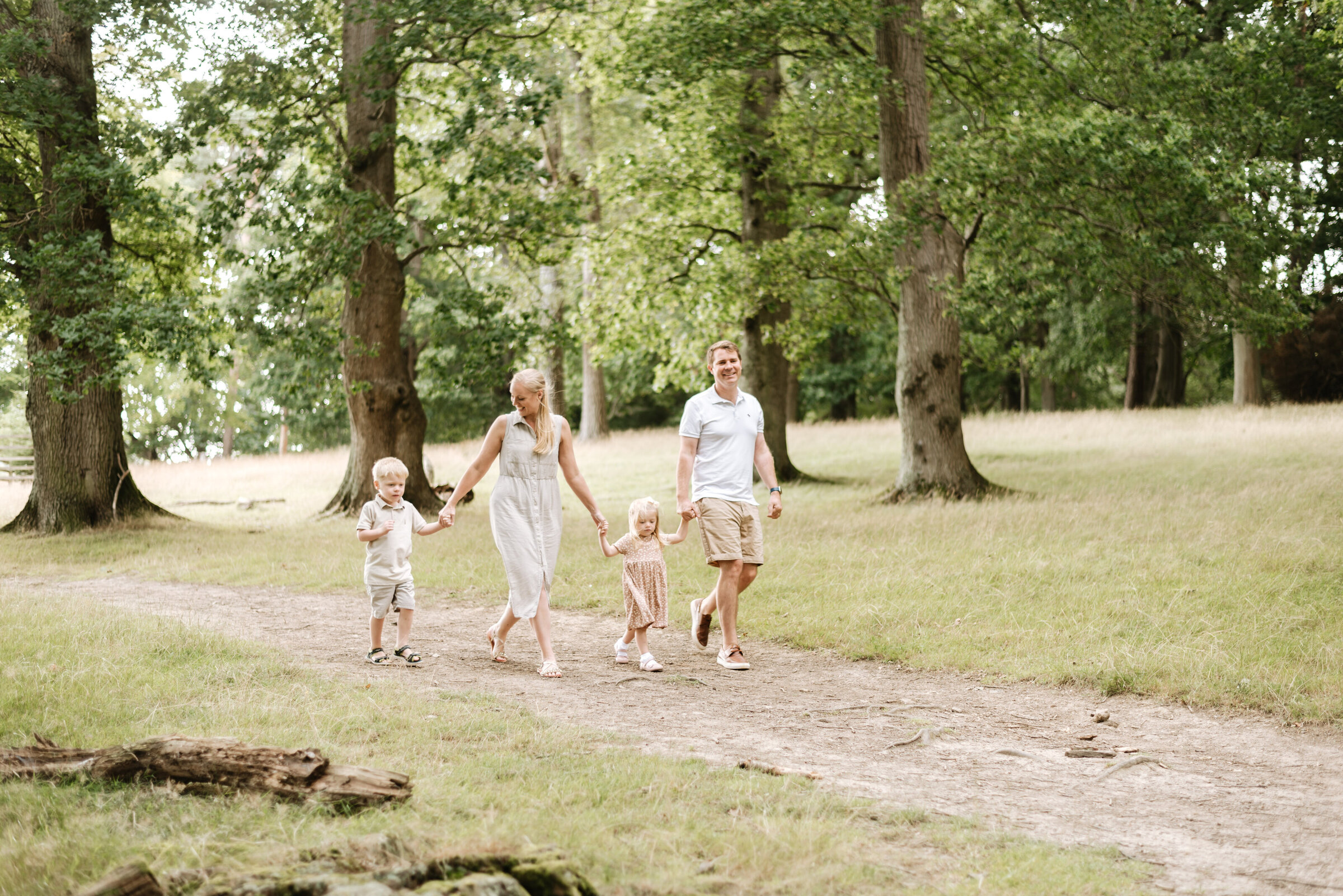 A family of four all holding hands walking in Billingshurst at a family photoshoot