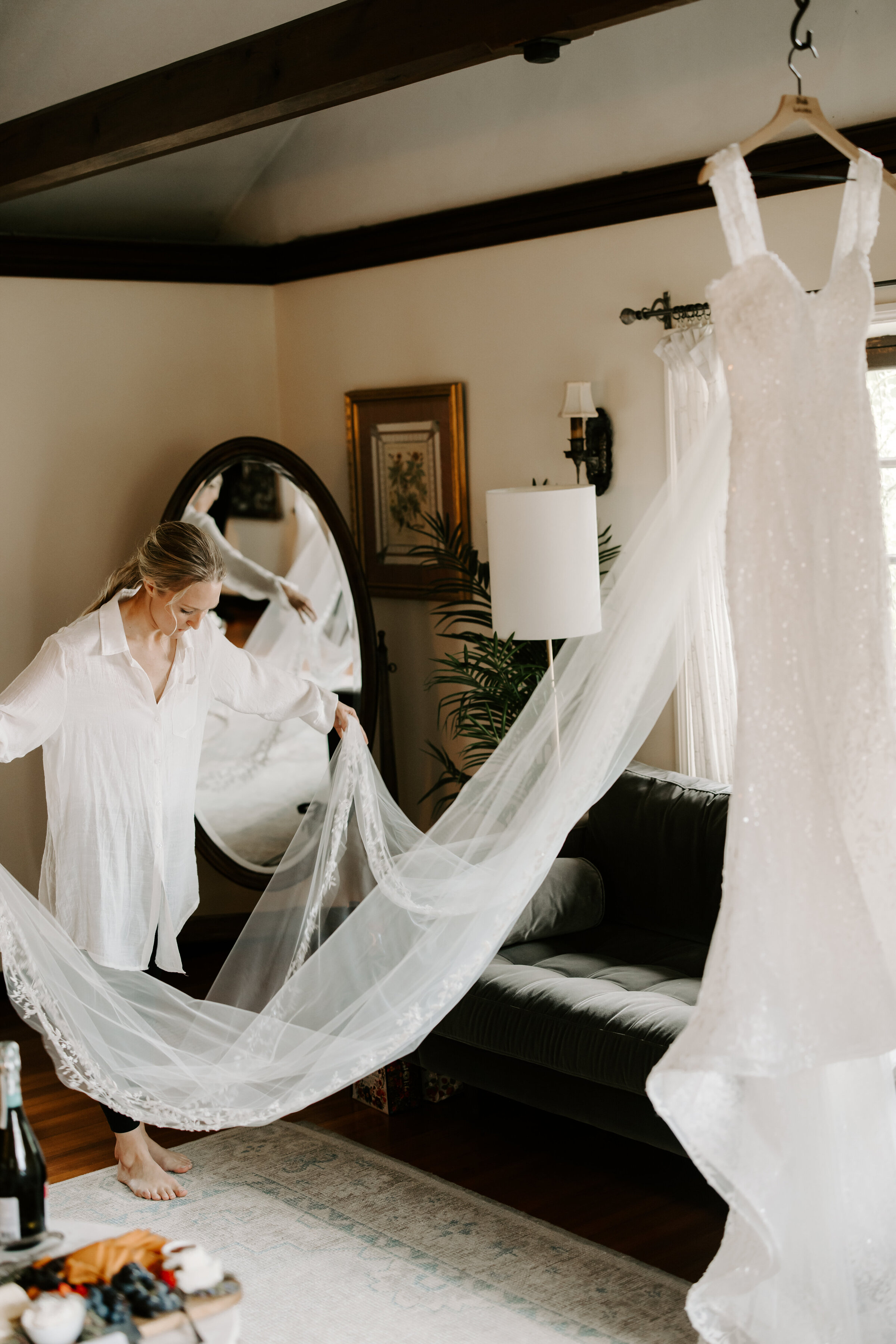 Bride steams her wedding dress and cathedral veil before wedding ceremony at The Willowdale Estate in Topsfield, Massachusetts