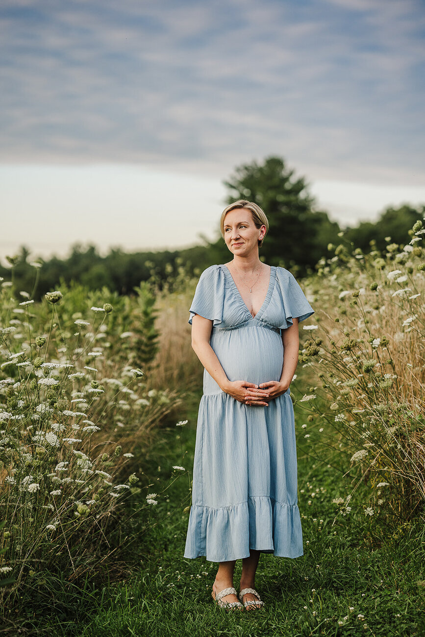 woman stands under overcast skies in a flower field in boston