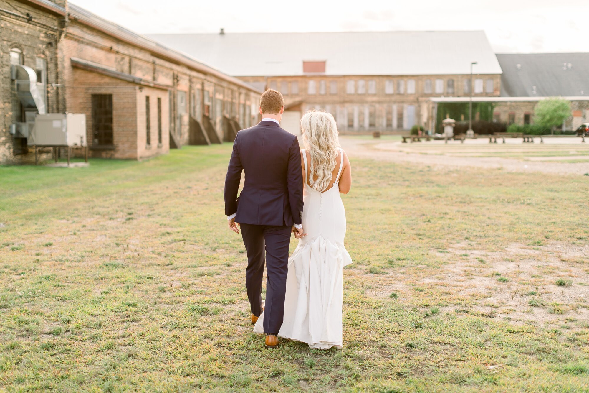 Bride and groom holding hands, walking toward wedding venue, taken by minneapolis wedding photographers