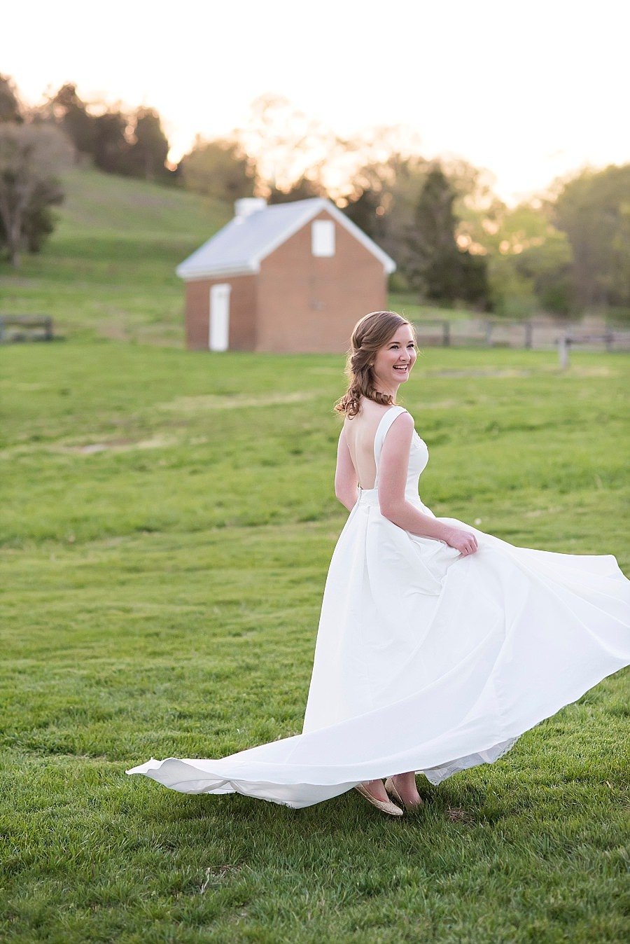 Bride twirling in her wedding dress during golden hour in the back courtyard at Ravenswood Mansion