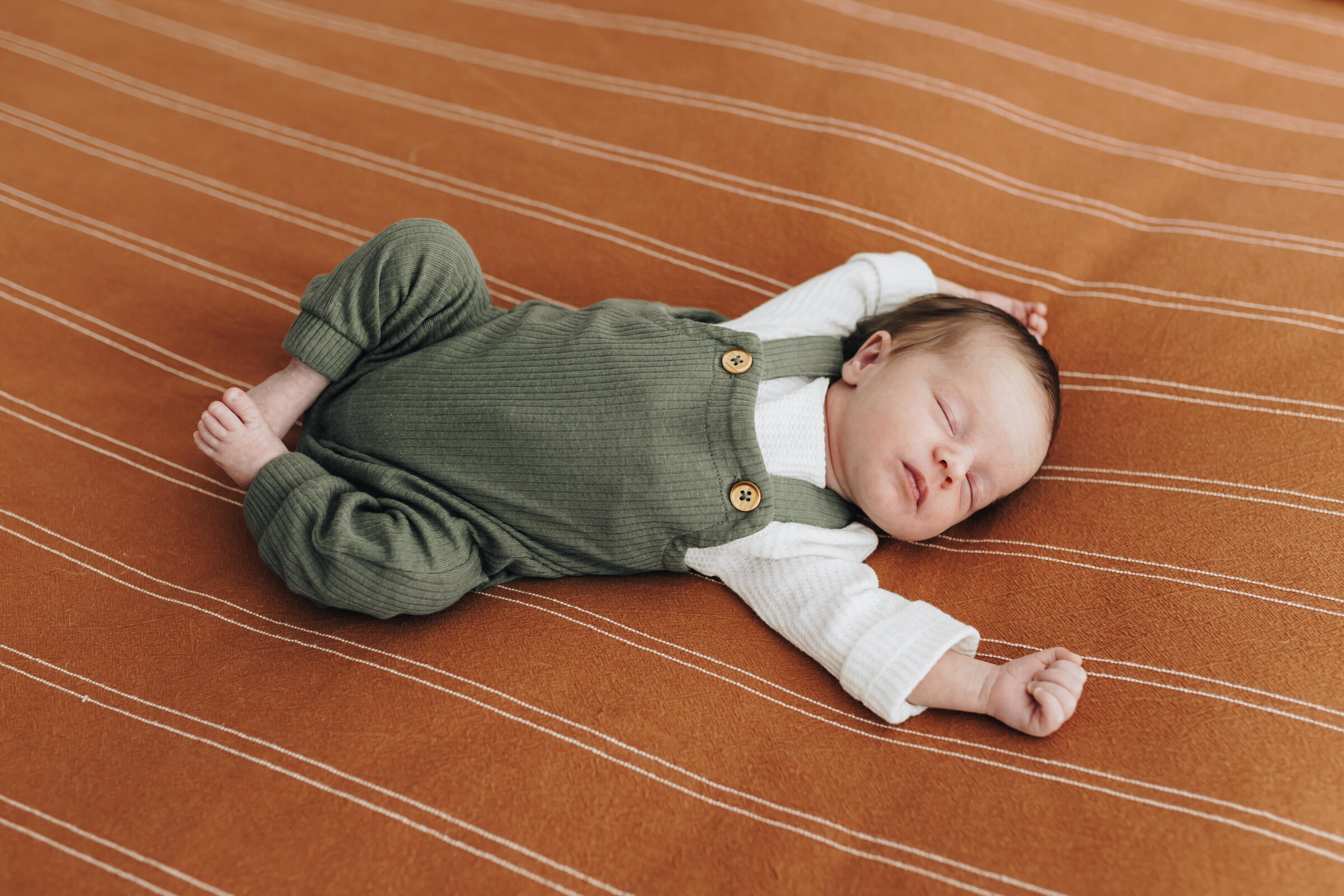 Baby Stretches in Sleep on Bed
