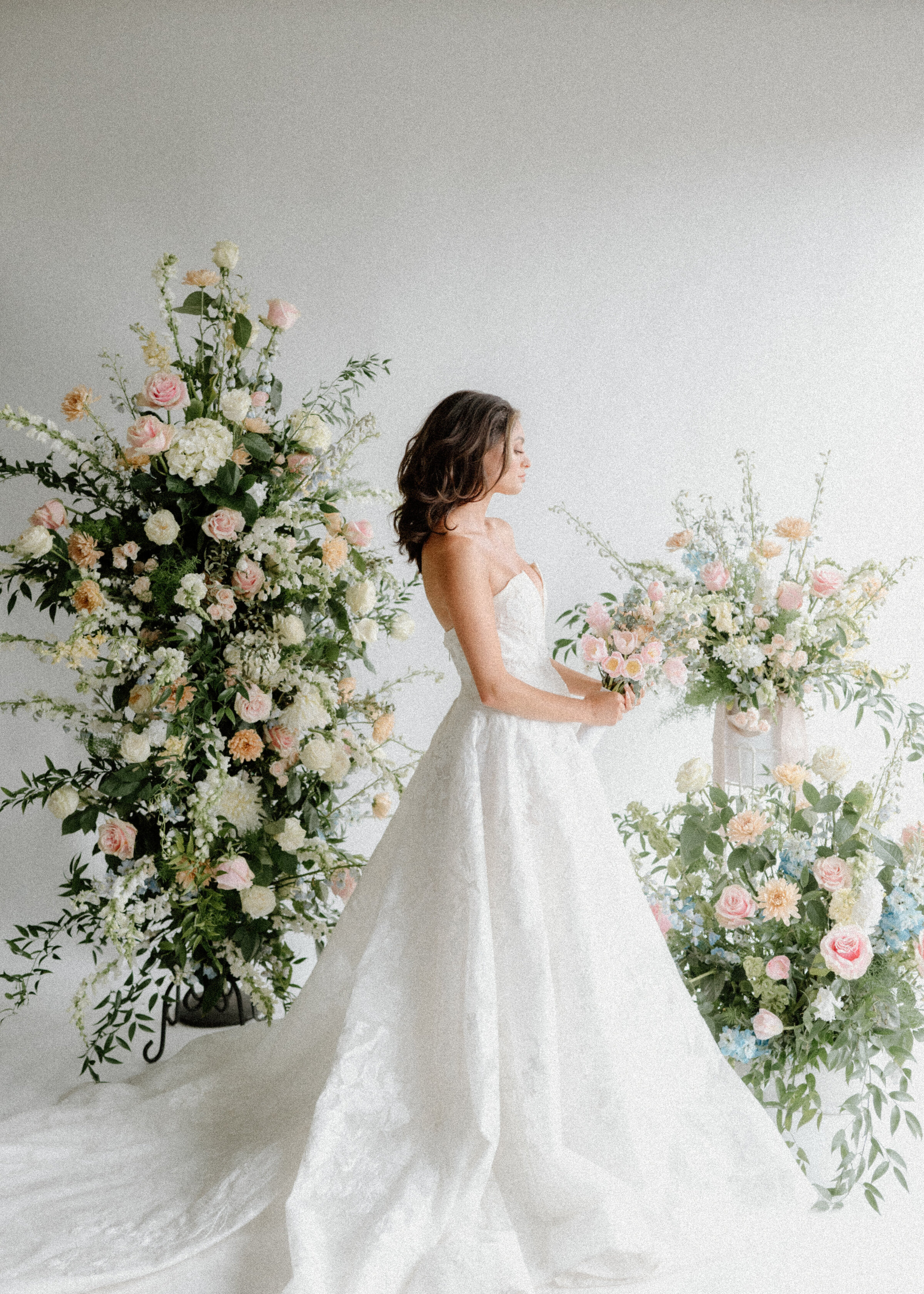 Bride posing in front of floral installation in studio
