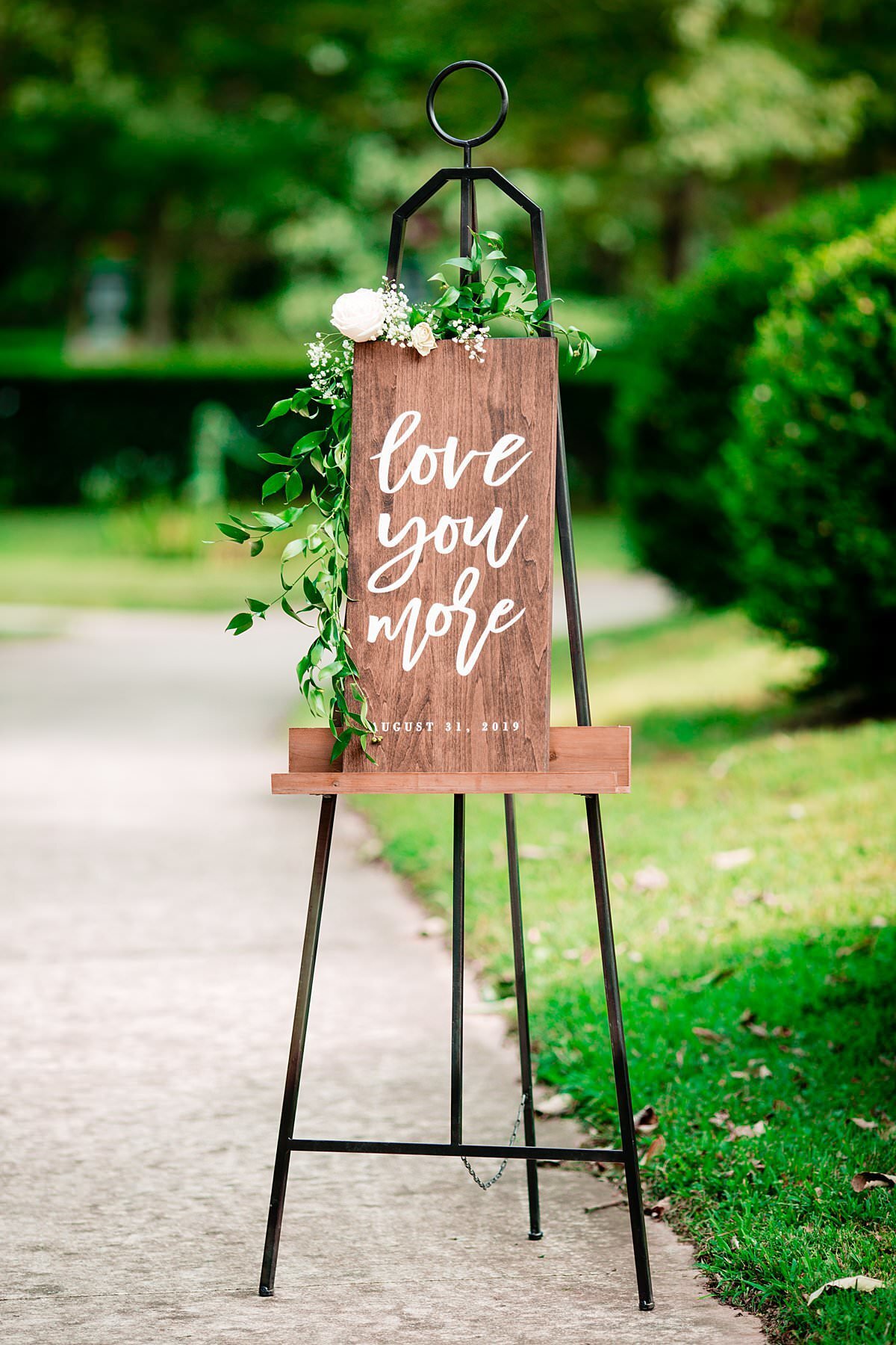 Wooden sign with Love you More calligraphy  welcoming guests