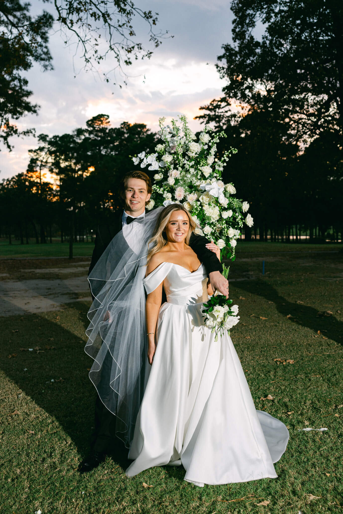 a posed image of the newly wed husband & wife with a sunset in the background at Texarkana Country Club