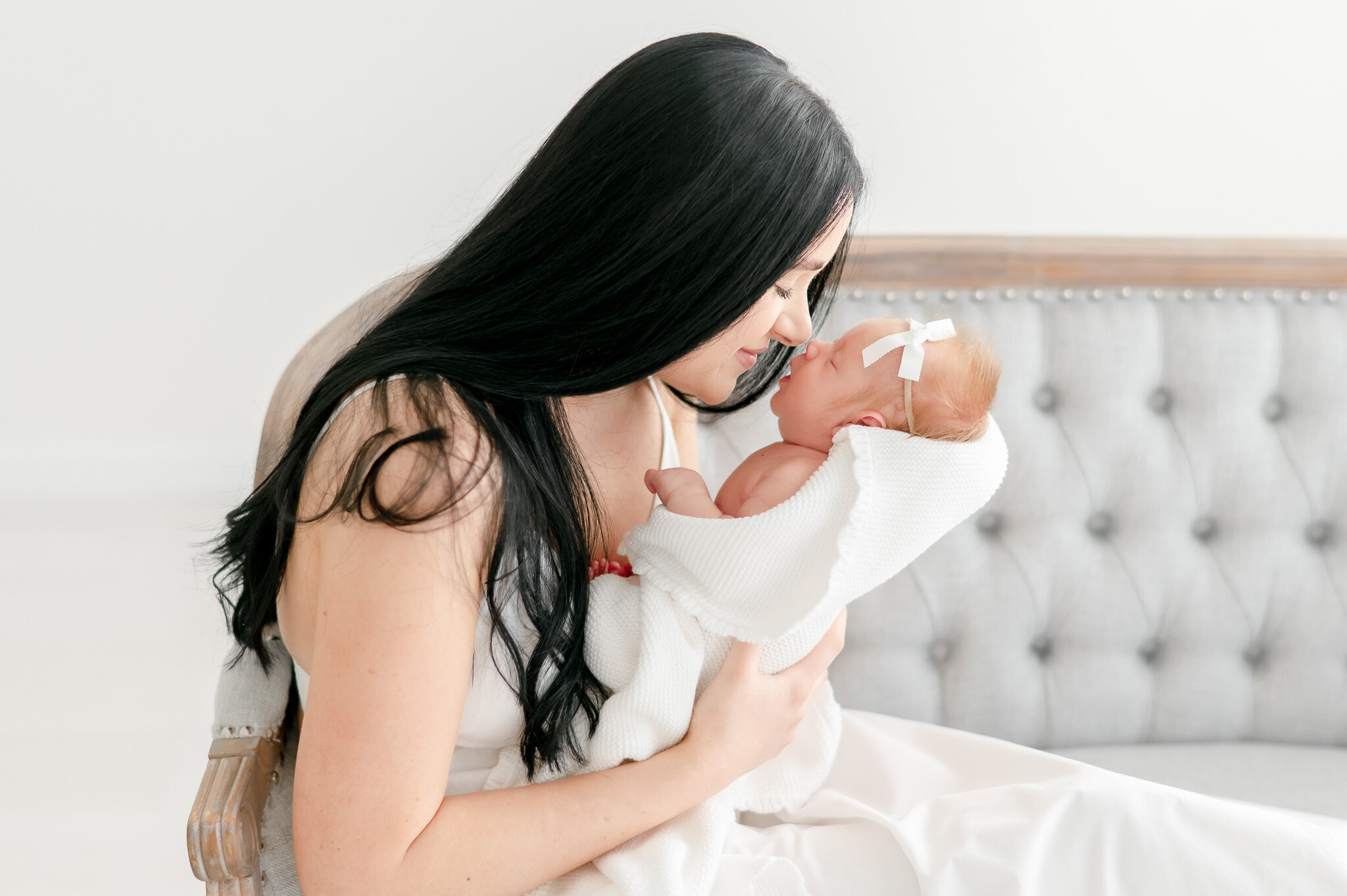 A mother leans in nose to nose  in Kristie Lloyd's Nashville newborn photography studio
