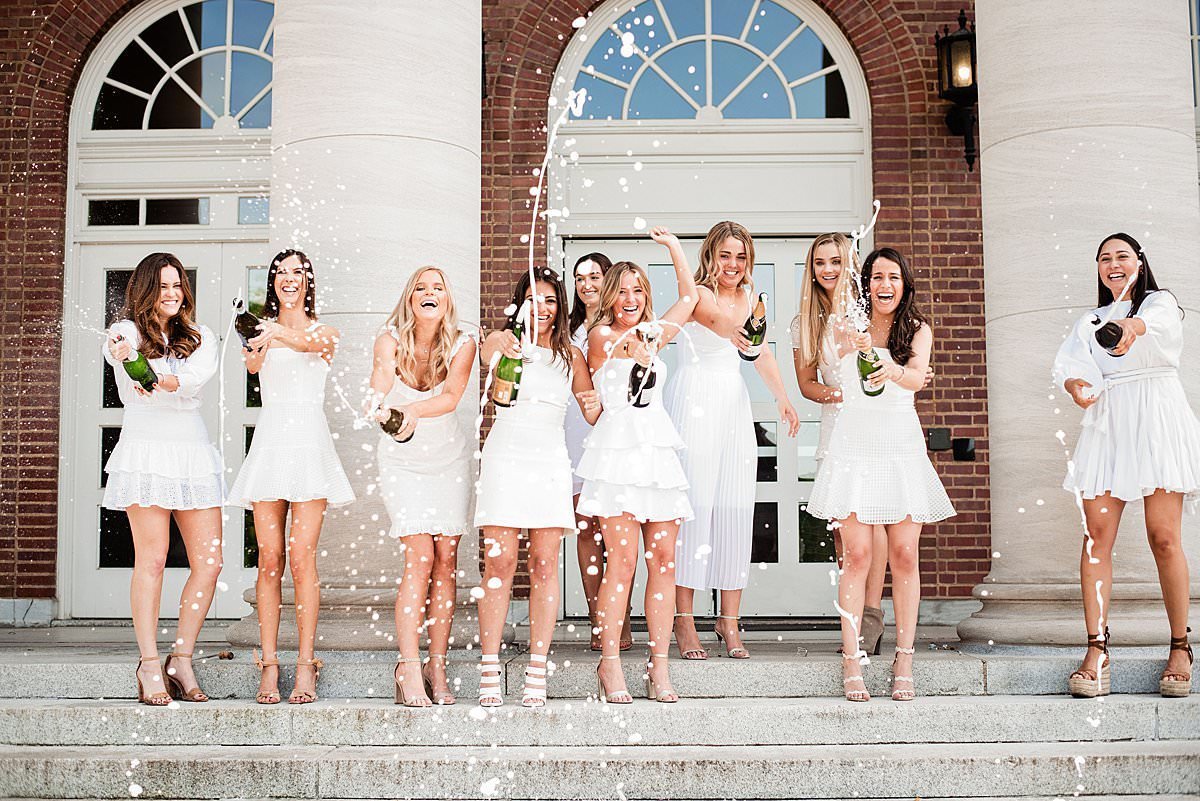 Kappa Kappa Gamma College Seniors on the steps of historic Vanderbilt building wearing cute white dresses and popping bottles of champagne to celebrate graduation