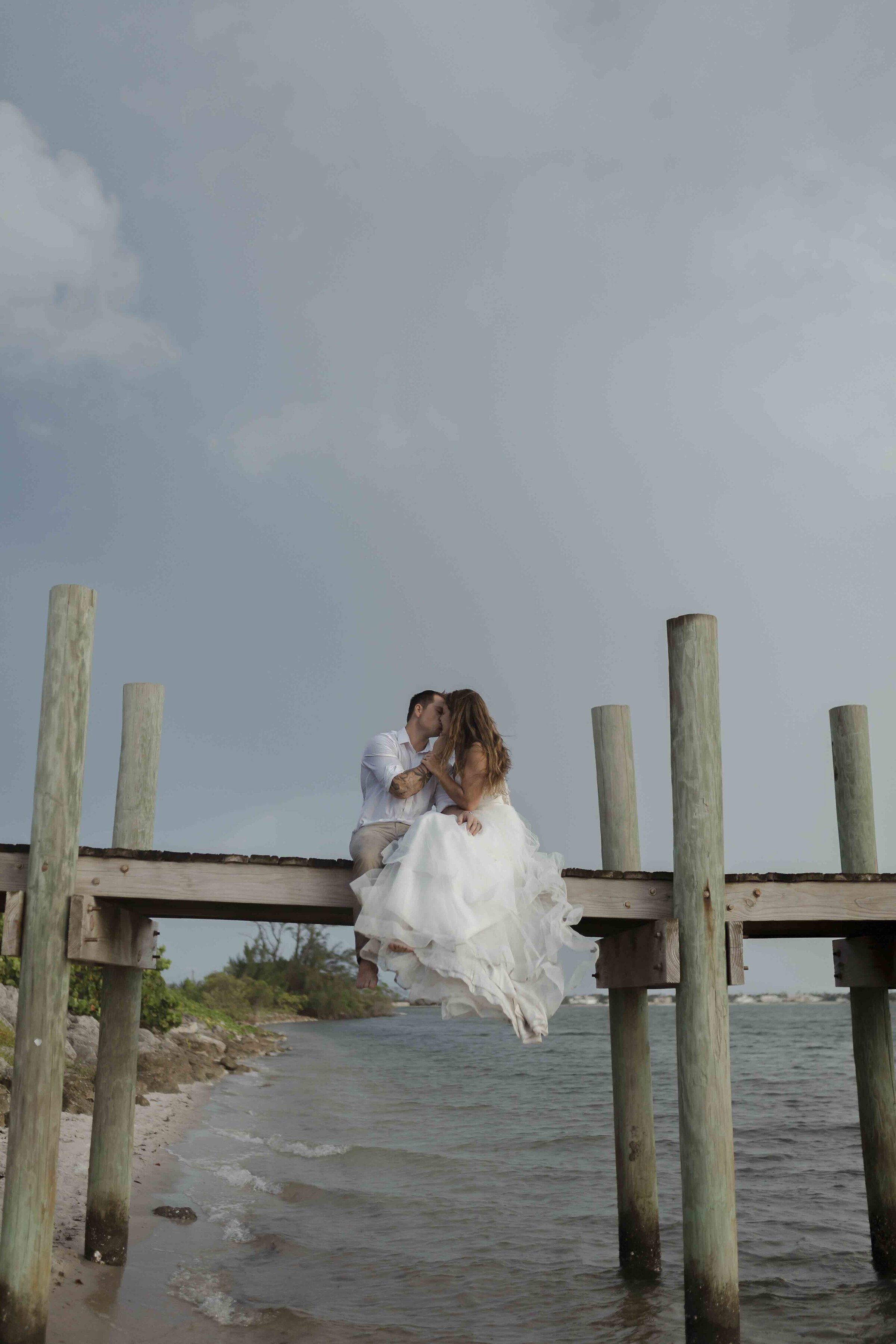 Bride and groom kissing on a pier