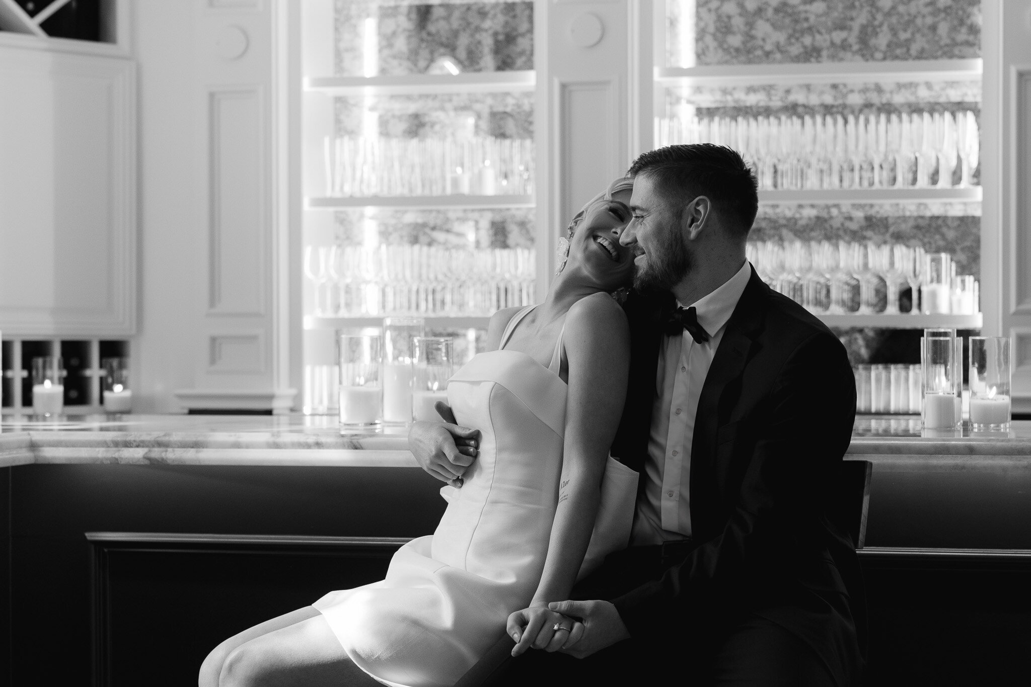 Couple in a loving embrace laughing together on their wedding day