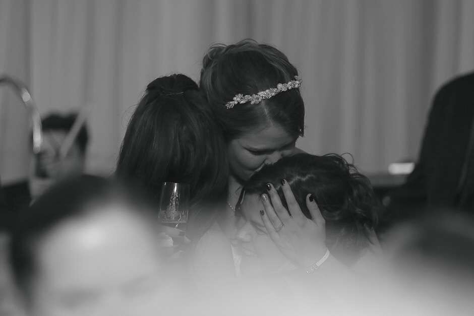 "Bride kissing her maid of honor on the head at Watermark Marina in Wilmington NC"