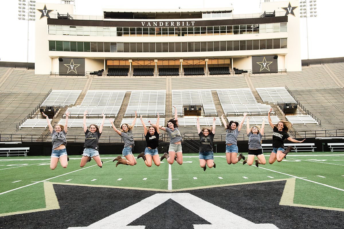 Kappa Kappa Gamm seniors jumping in air together on the Vanderbilt football field
