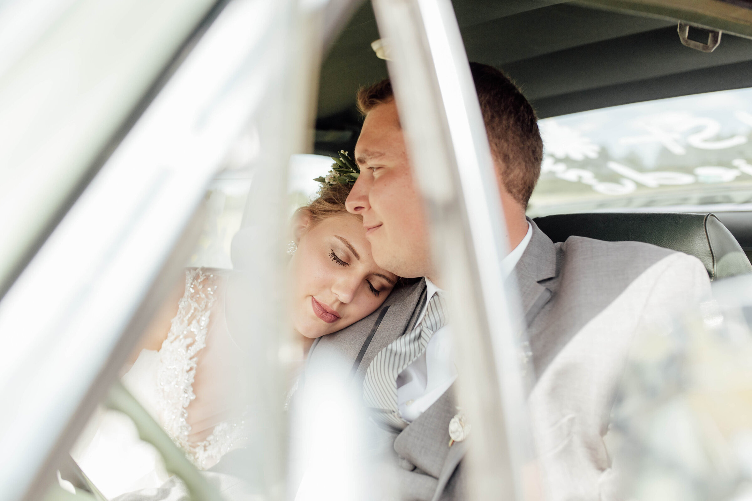 Bride and groom in old sports car. 