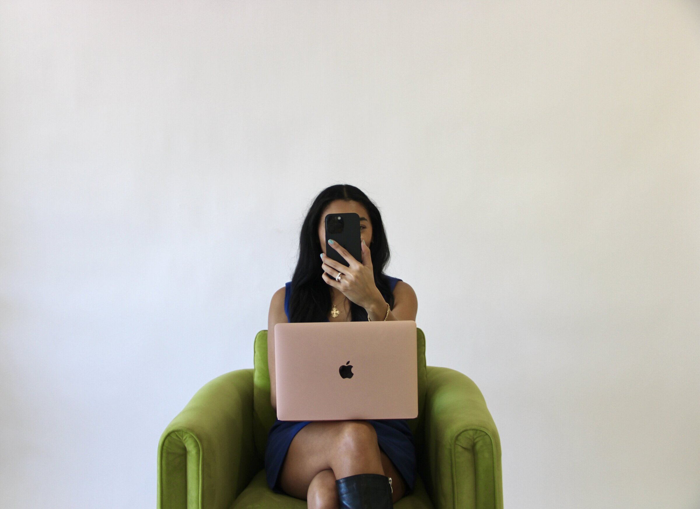 Bri, founder of One Eleven Social Studio, sitting with her laptop and holding her phone, ready to help you launch your website in one week.