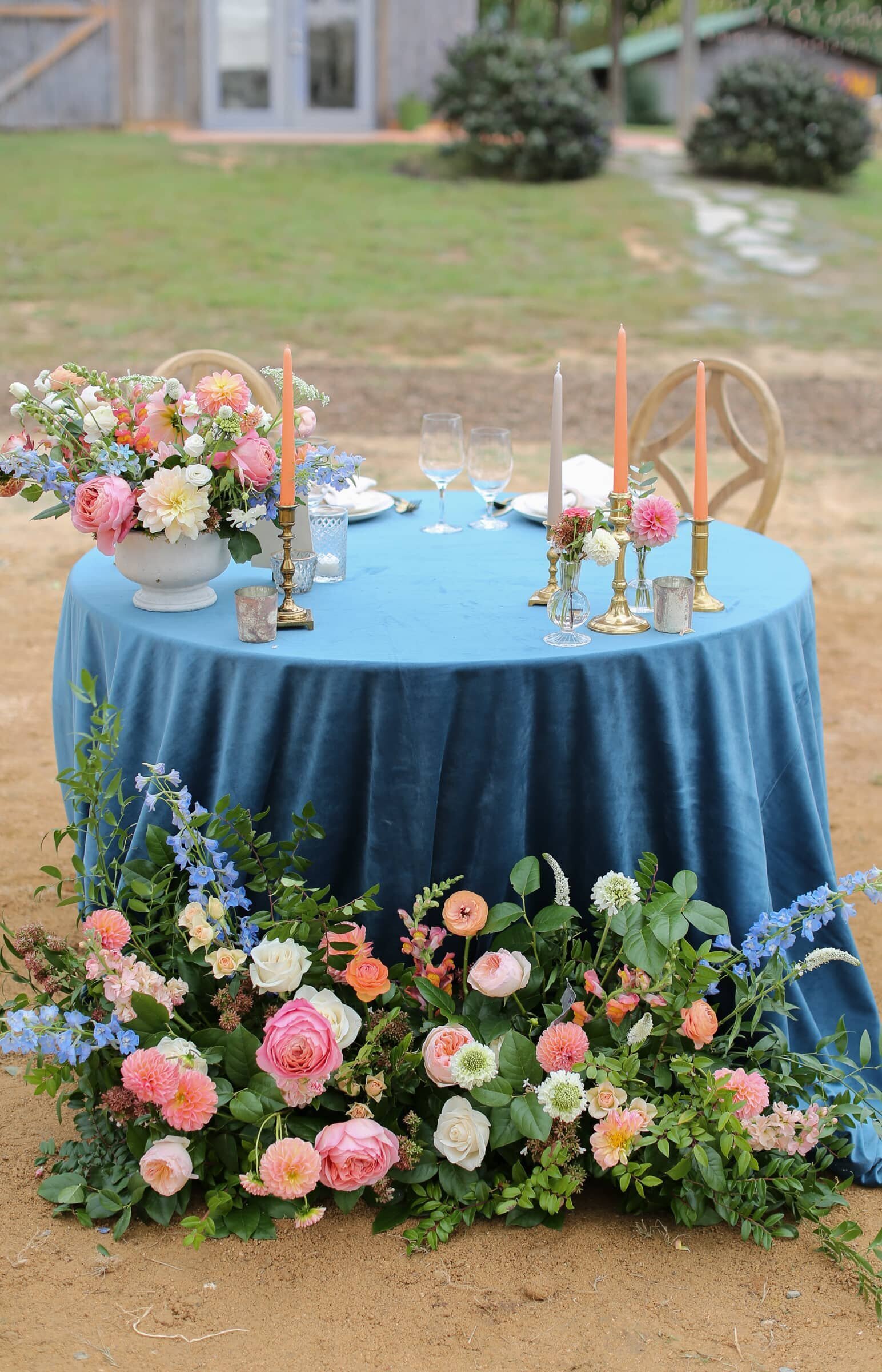 sweetheart table with blue velvet tablecloth and orange flowers