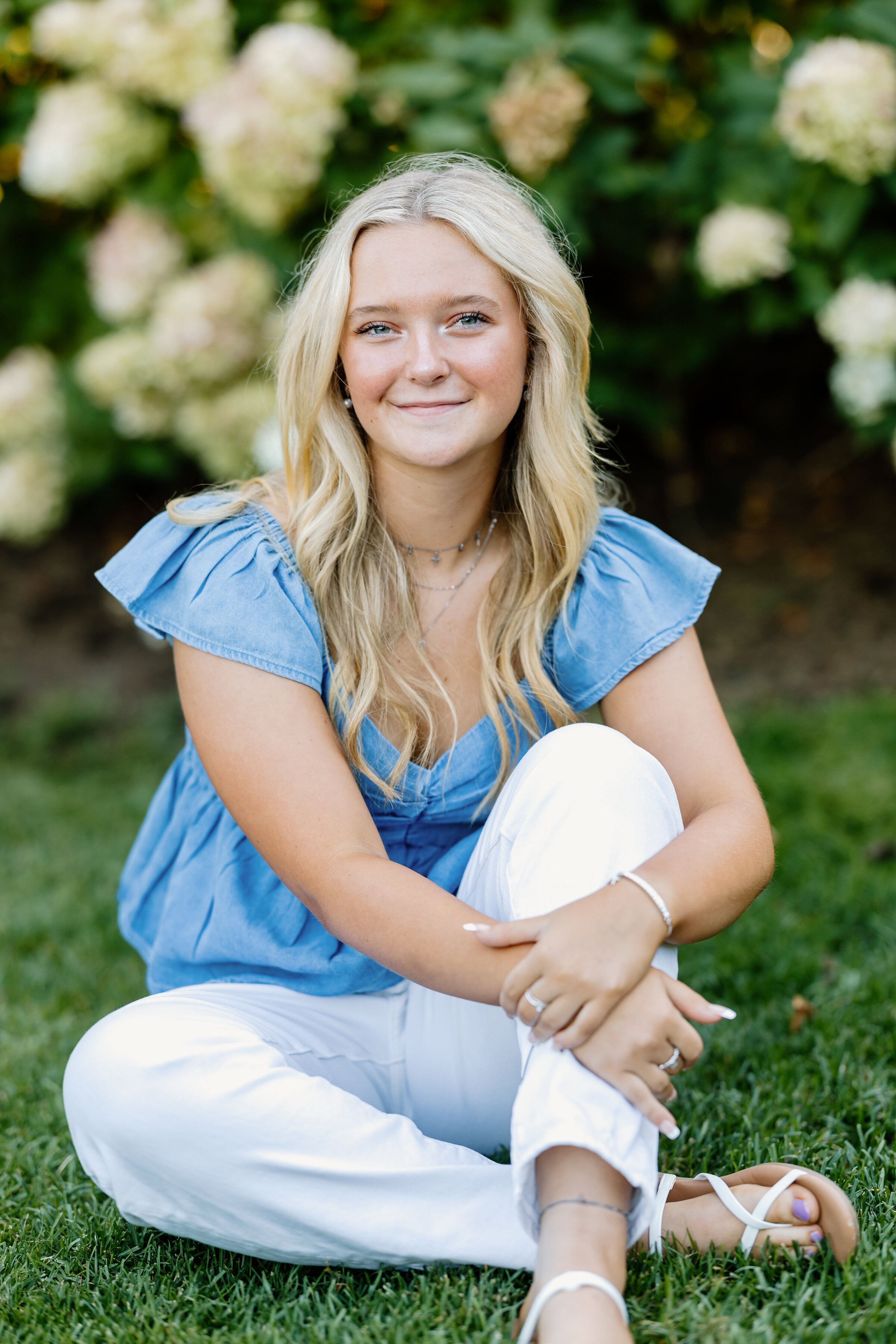 Senior girl photo sitting by flowers in blue shirt in Beverly, Massachusetts