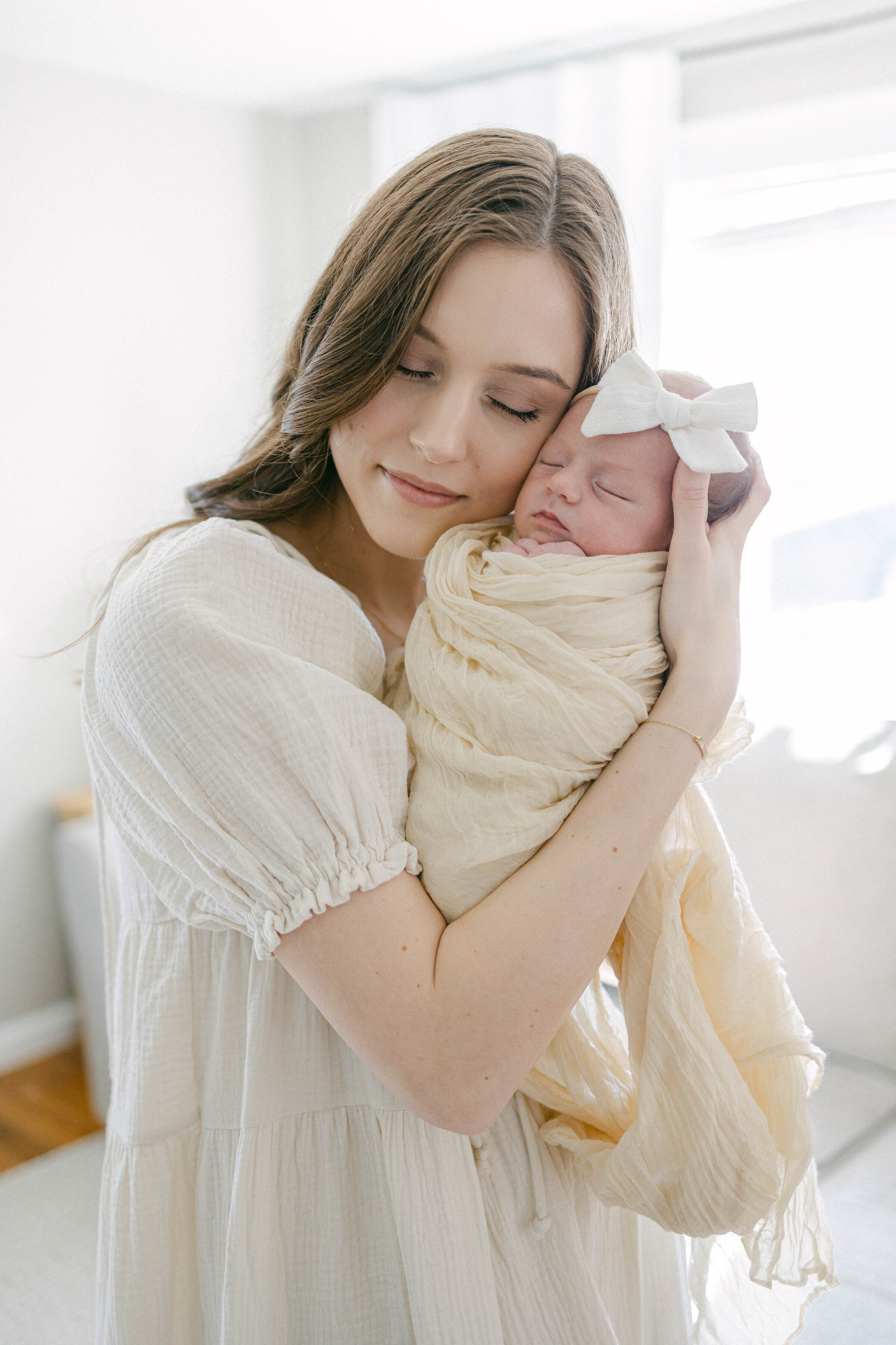 women holding swaddled newborn face to face with eyes closed  knoxville tennessee newborn photographer