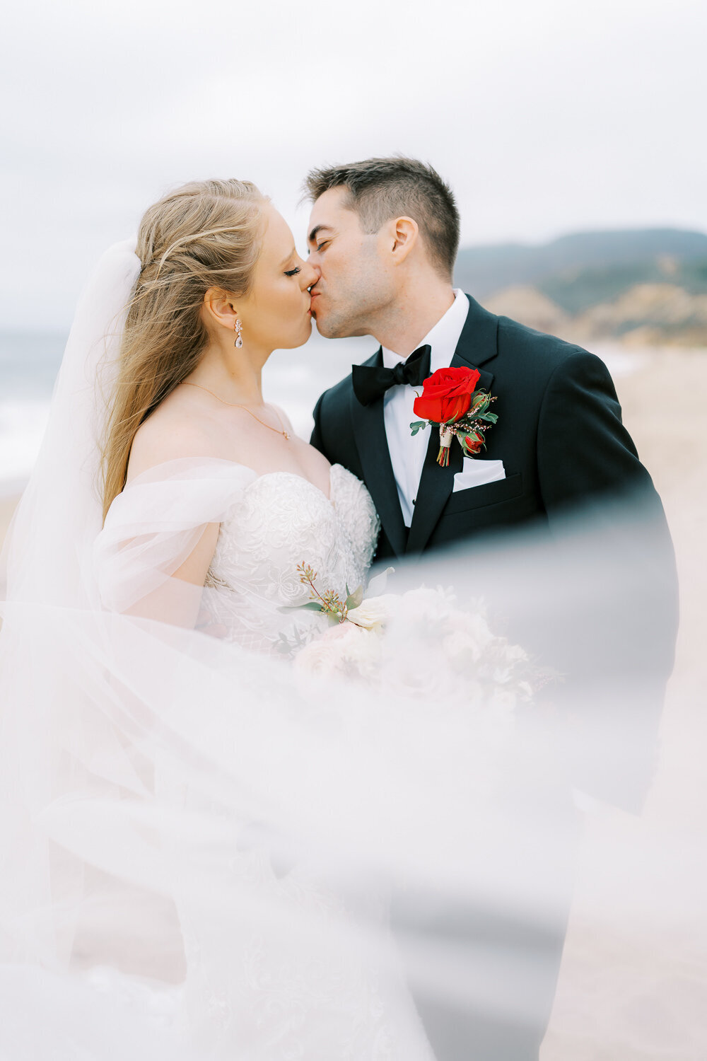 couples portrait session on the beach with veil