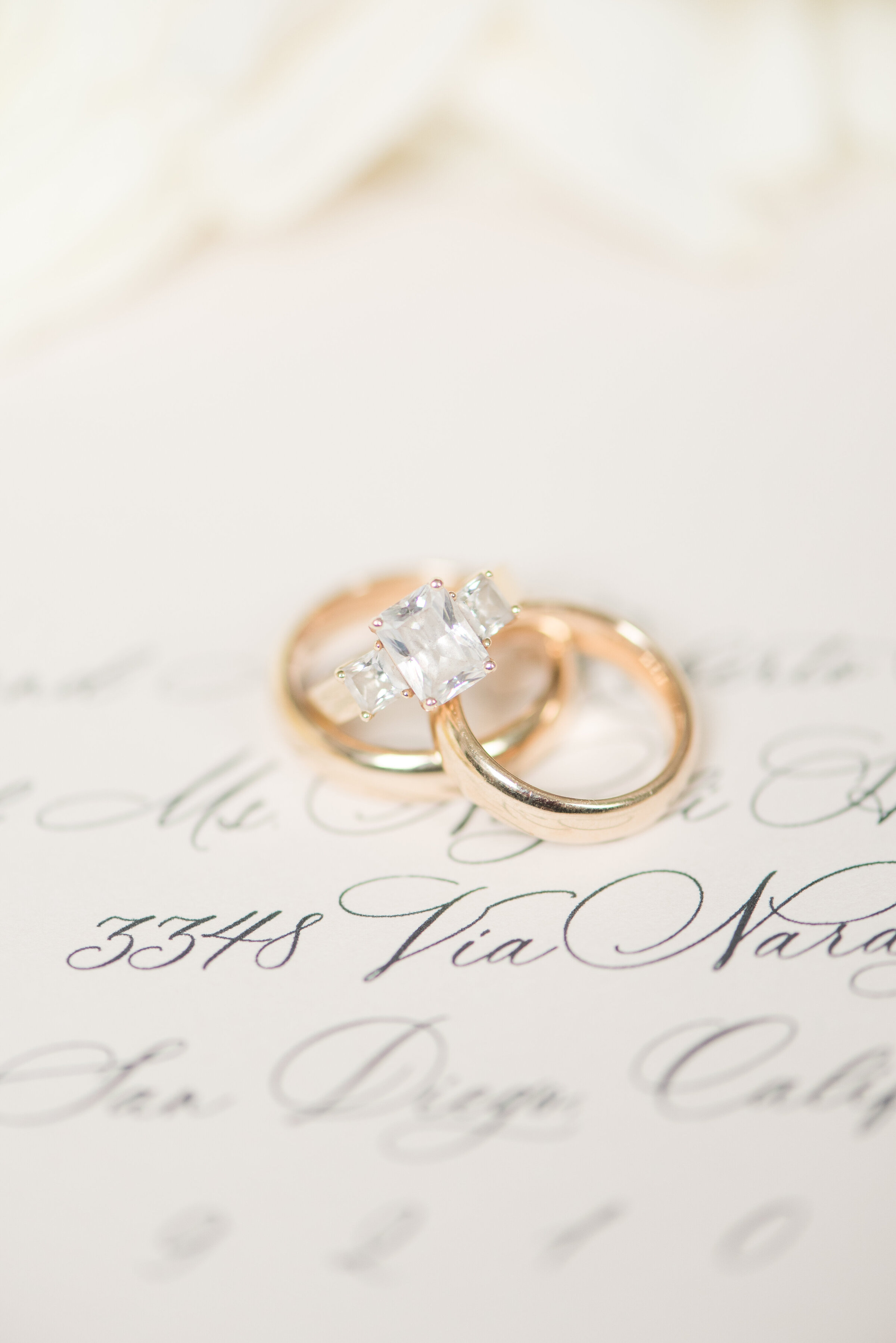 close up of wedding rings on a calligraphy background