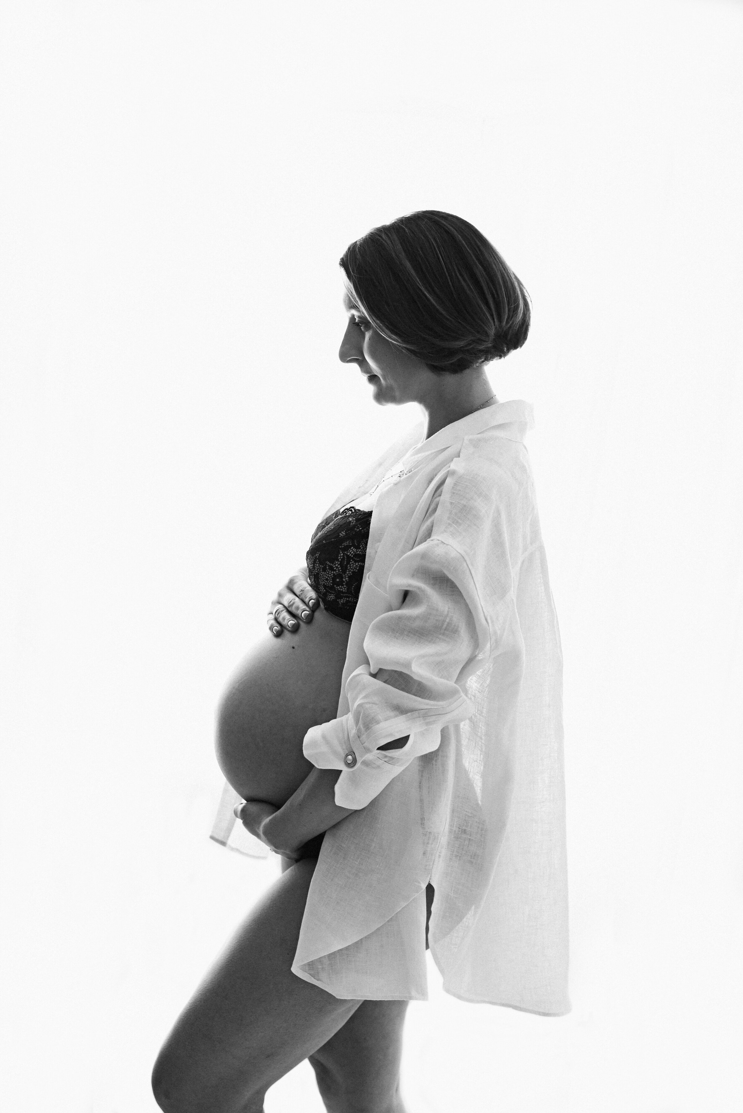 Pregnant mother holding her belly at maternity photoshoot in Billingshurst