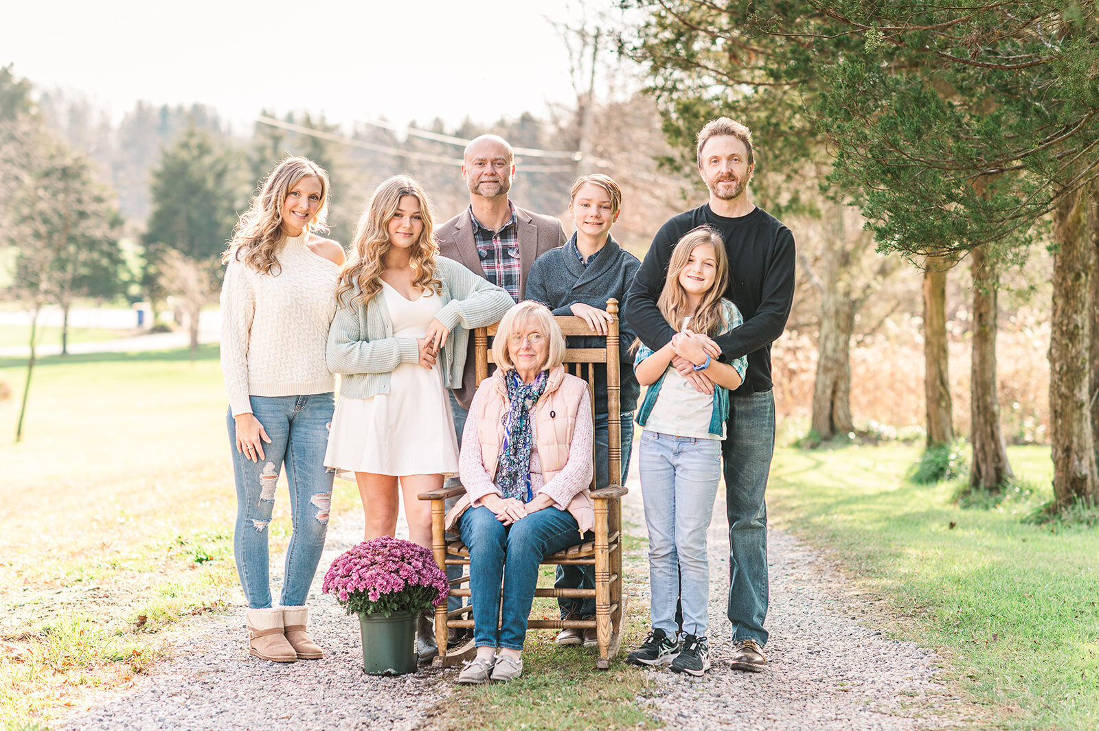 large family standing together with grandmother in the middle sitting on a rocker by harrisburg pa photographerr