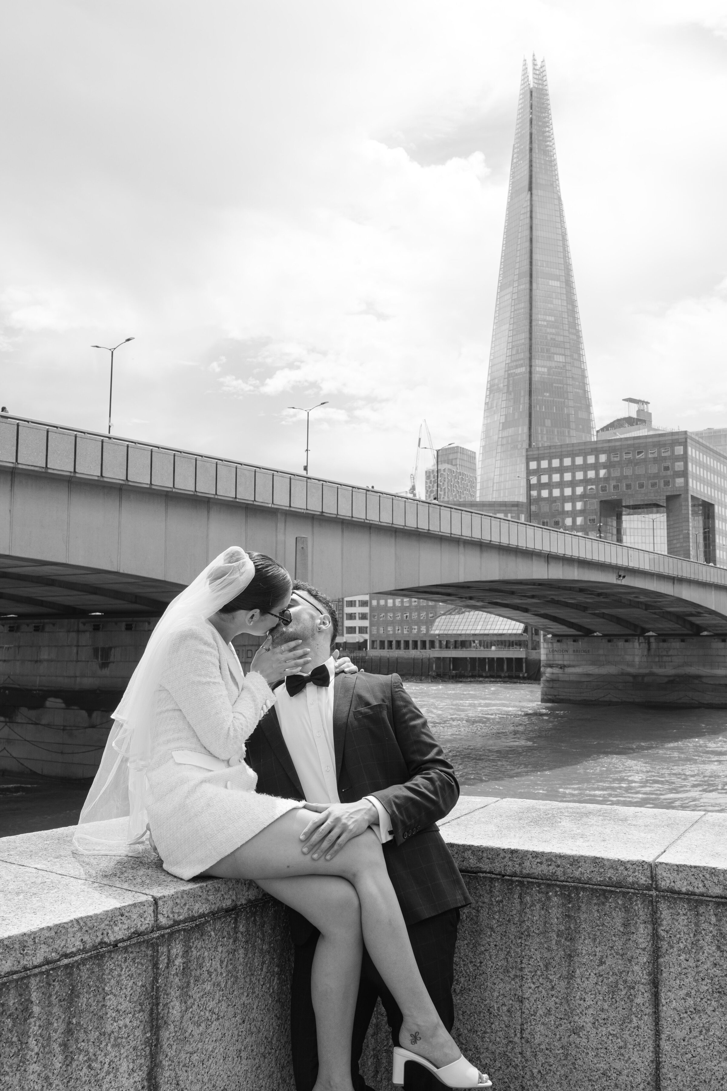 Black and white photo of elopement couple kissing in front of The Shard and London Bridge – modern city wedding by Ch Ramos Photography