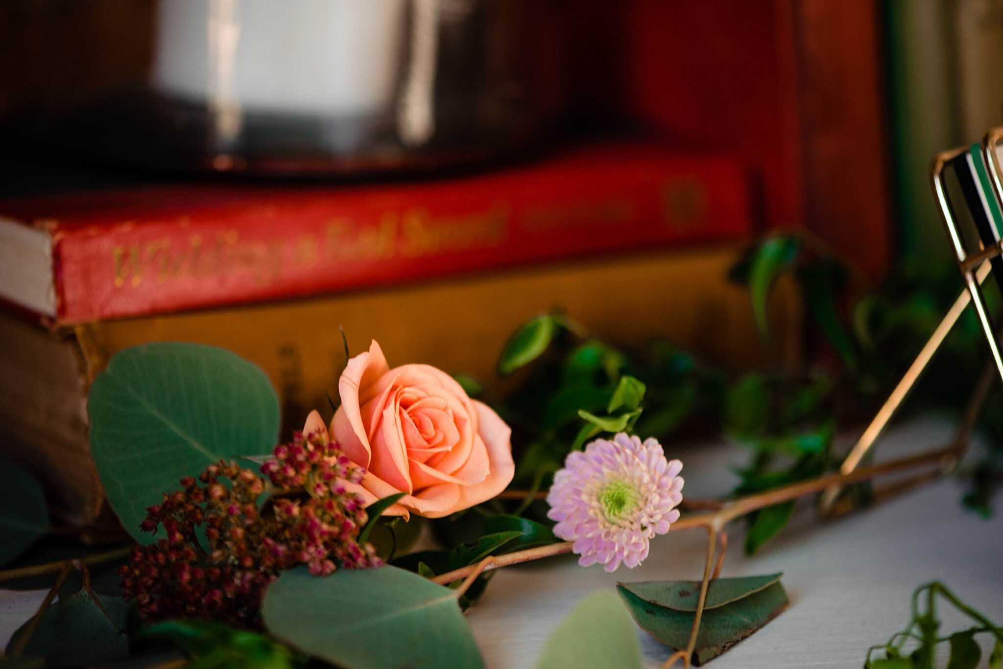Detail photo of small flowers and vintage books decorating a table centerpiece