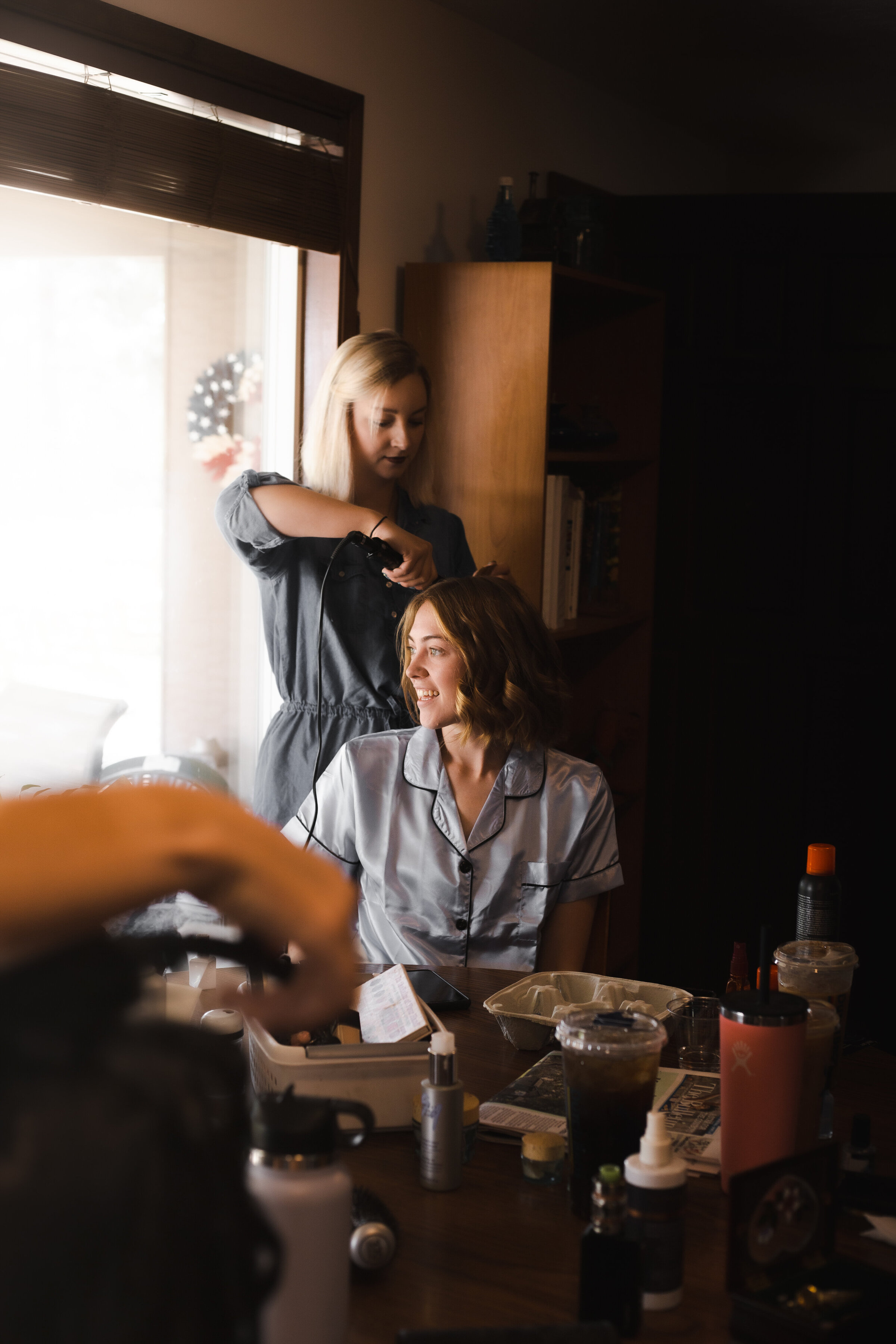 gettting ready photos during wedding, beauty team hairstylist doing hair for bridal party