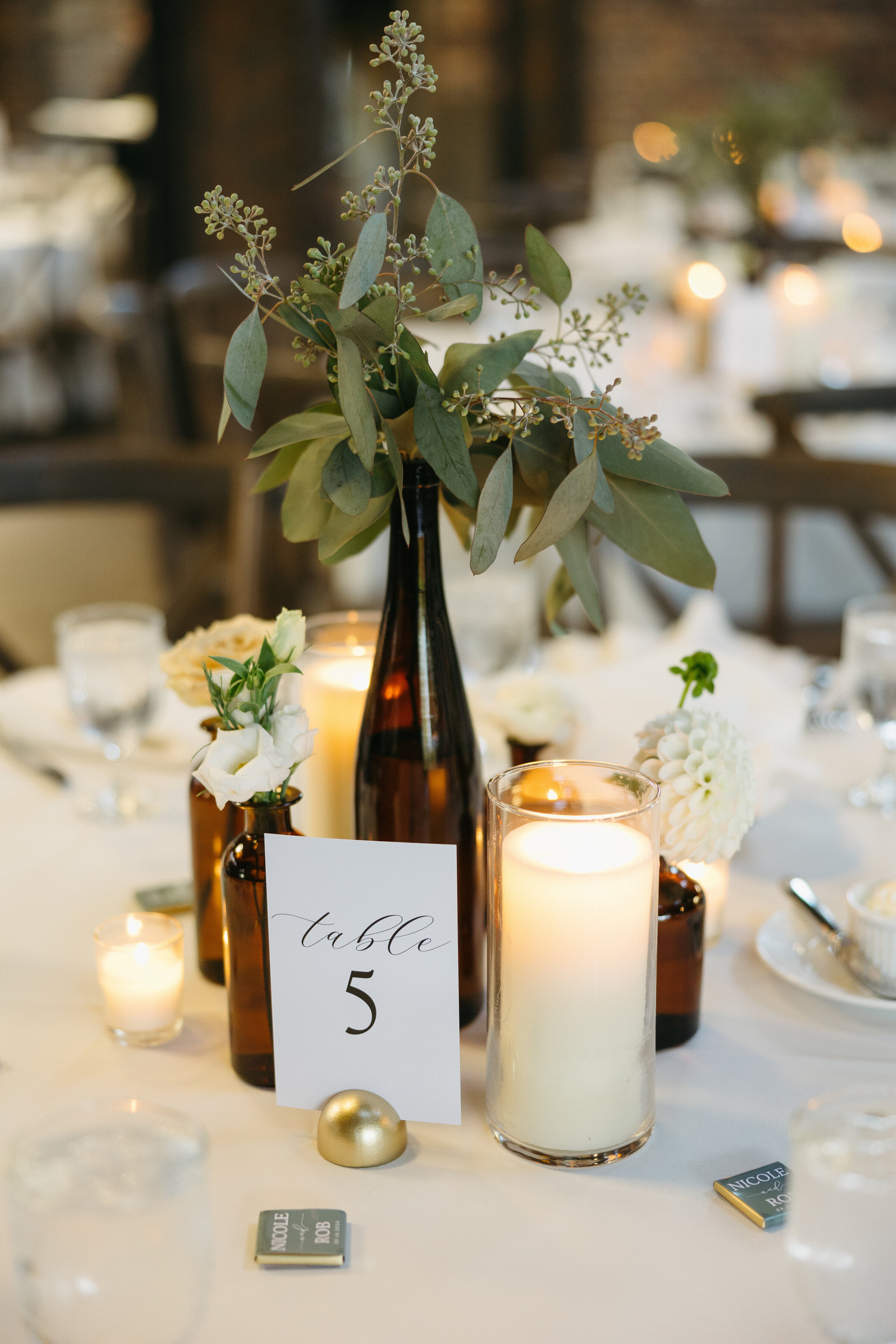 Enhance your event in Columbus, OH with stunning centerpieces featuring amber vases, elegant candles, and stylish table numbers. Perfect for creating a warm, inviting atmosphere.