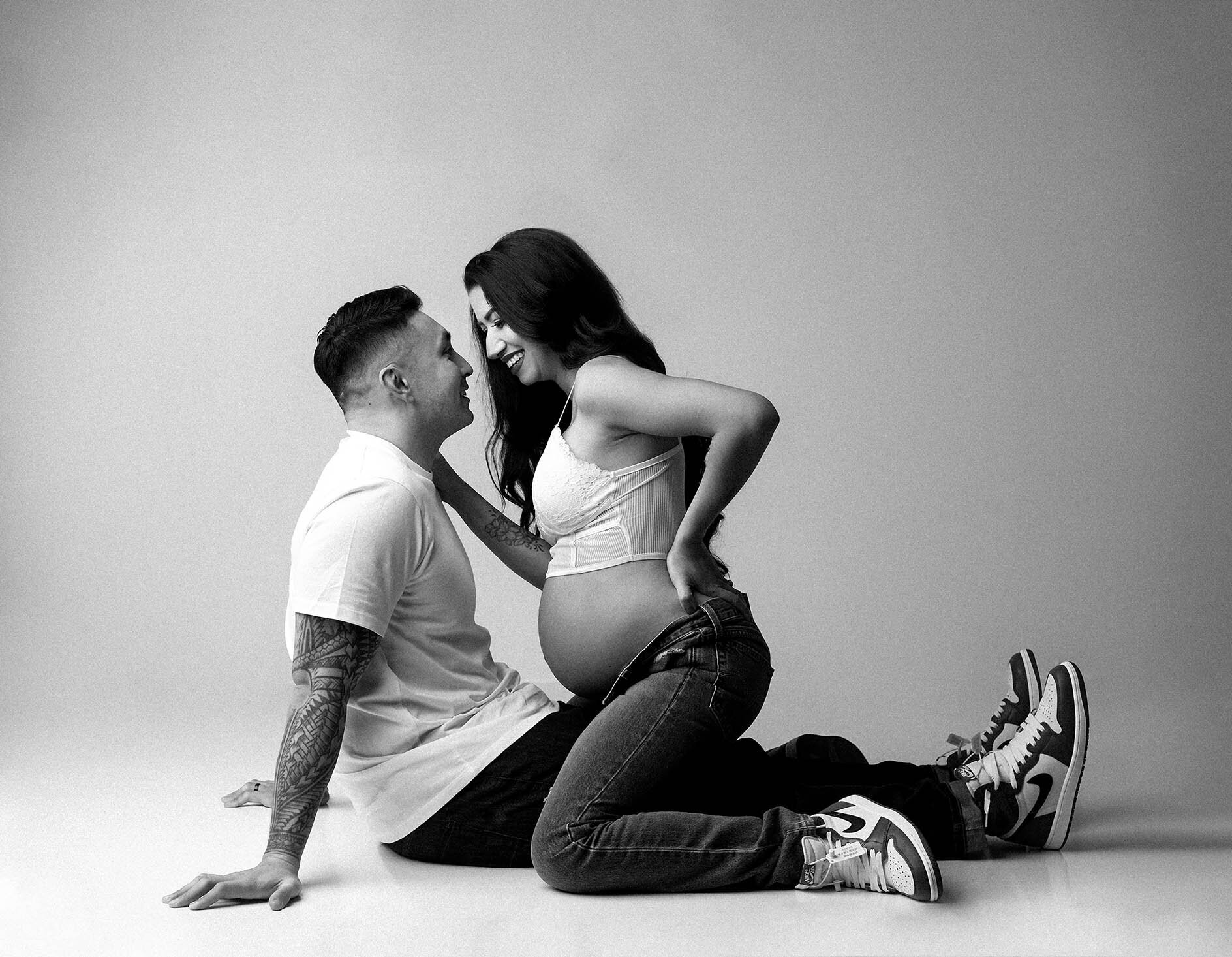 Black and white maternity image of husband and wife in a Vancouver Photography Studio