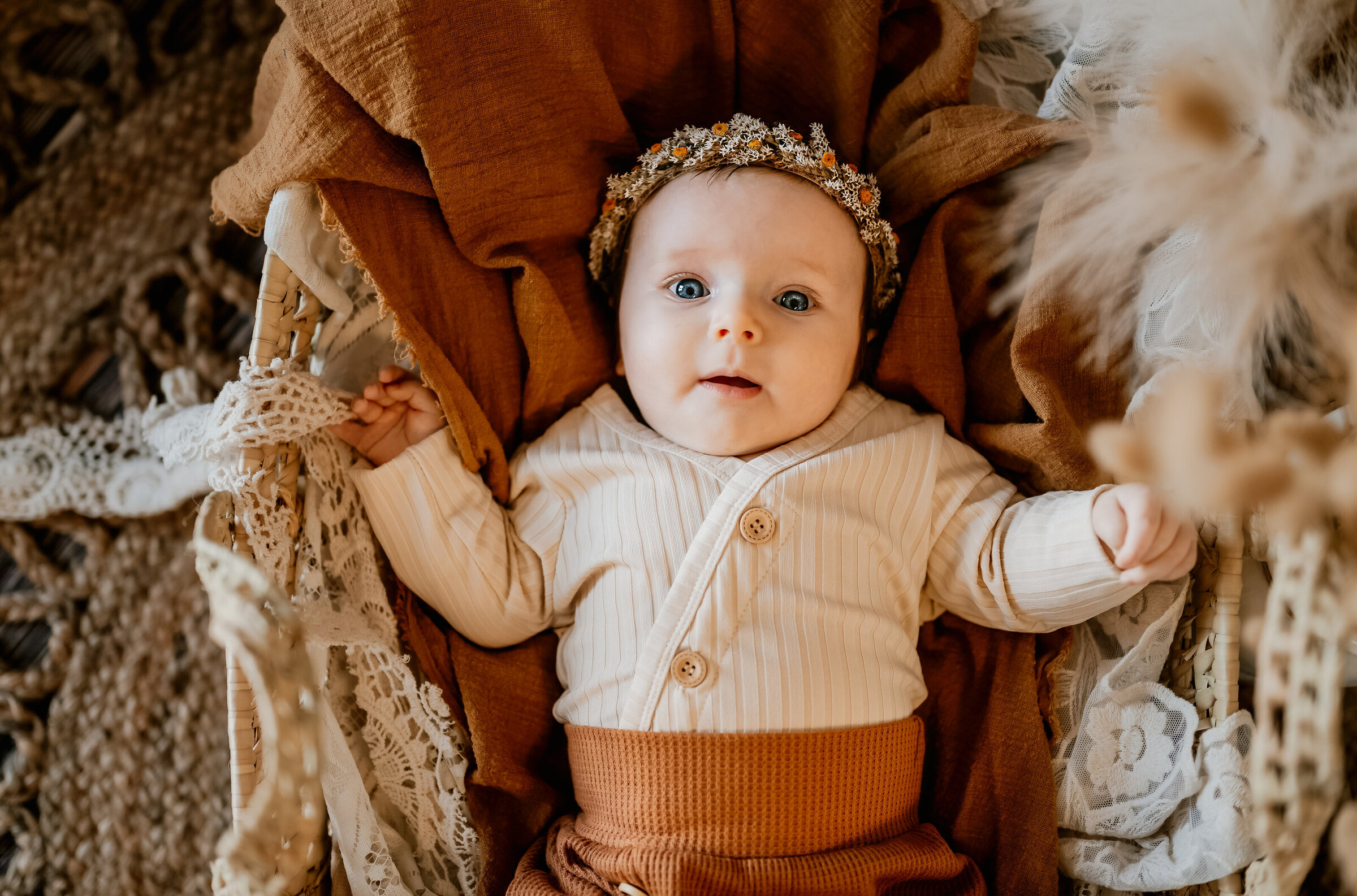 Three month old in boho outfit in moses basket for milestone photos