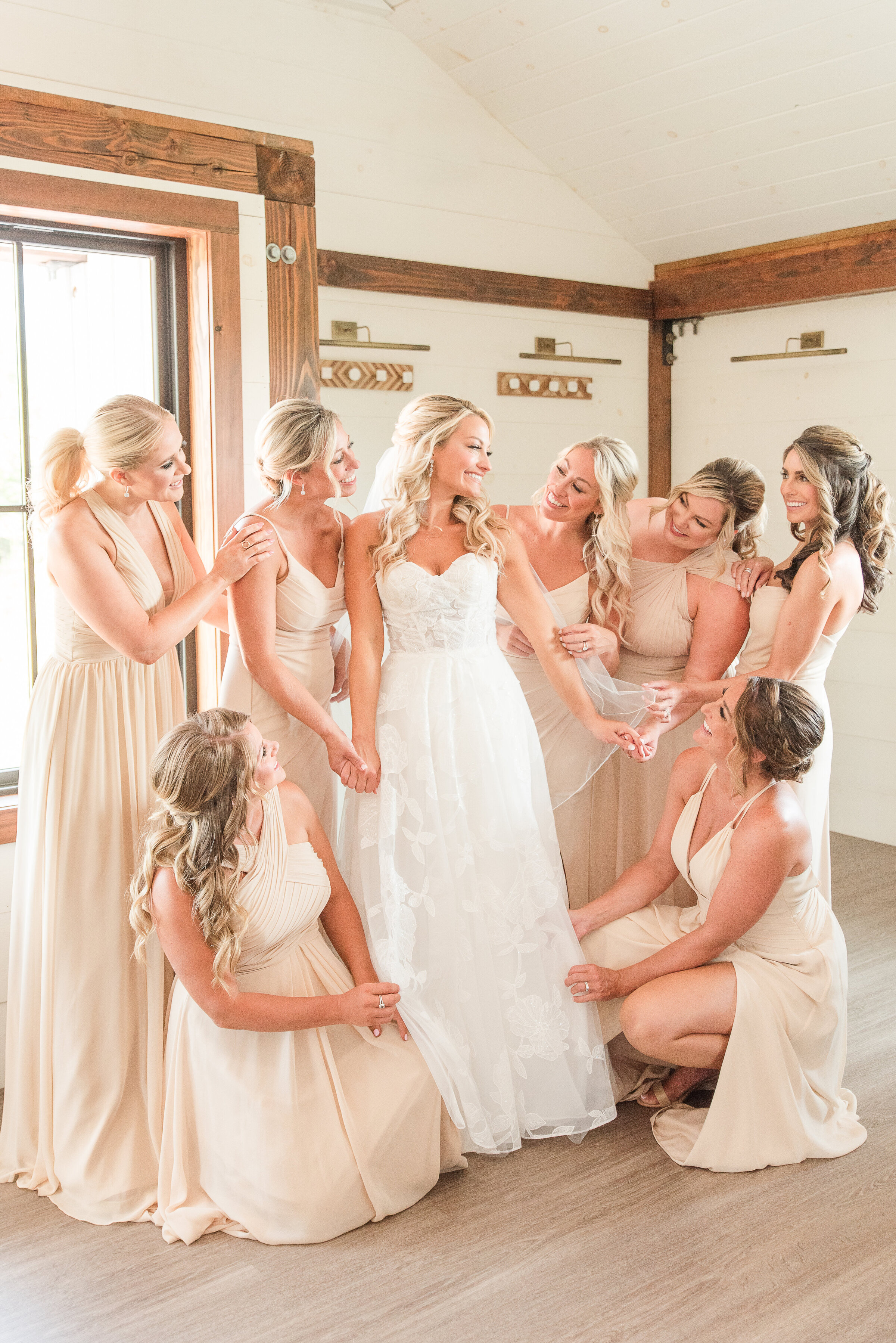 bride surroubded by brisdemaids in a luxury barn