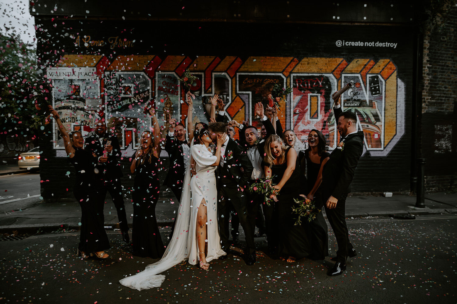Group shot of wedding guests outside Brixton mural