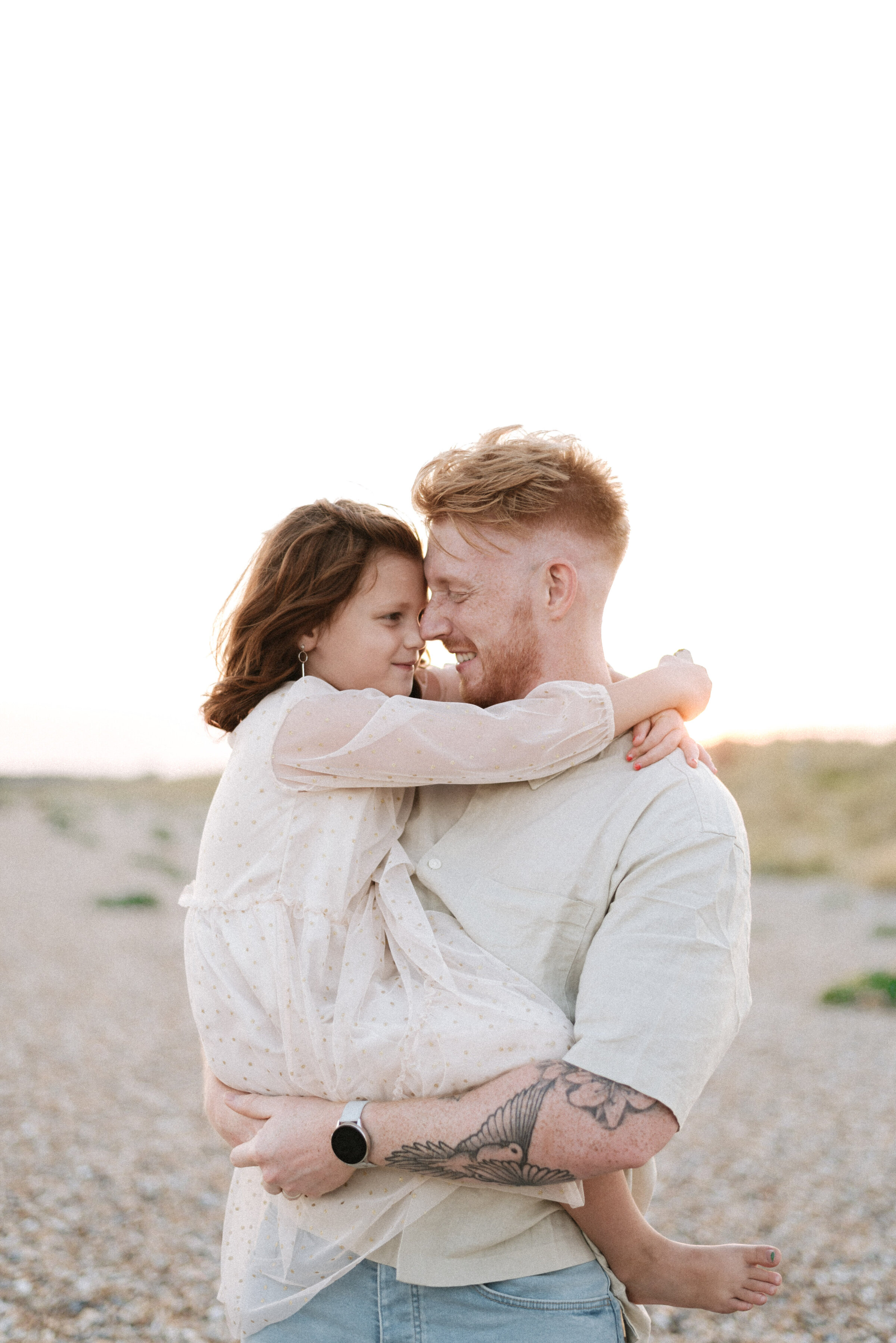 A dad holding his daughter cuddling in Billingshurst family photoshoot