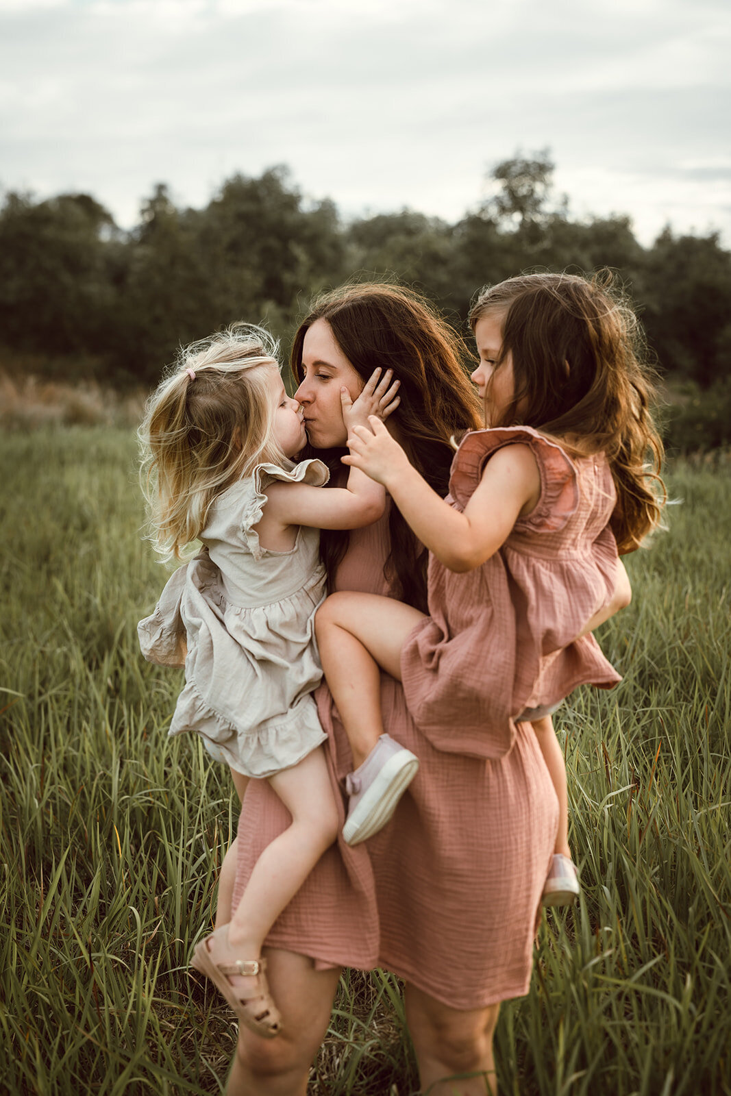 motherhood shoot with a mother and her two daughters, spinning and hair wild 