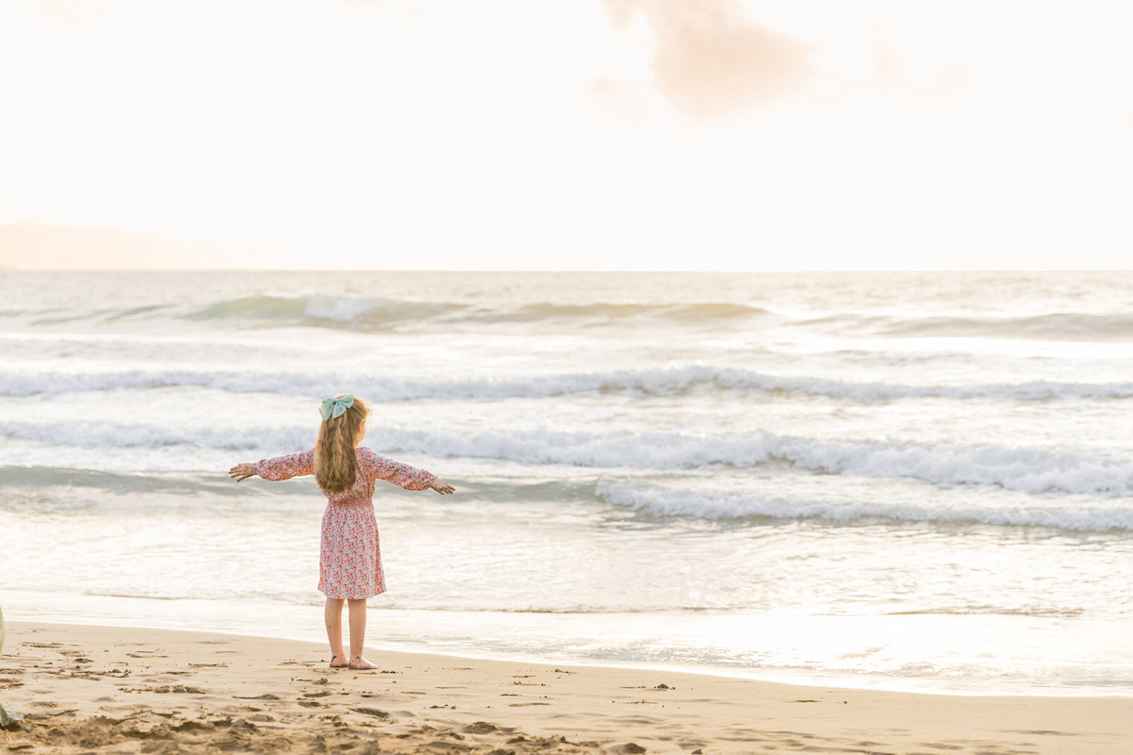 Adorable Maui, family photo of little girl, dressed in floral, dressed, looking towards the ocean