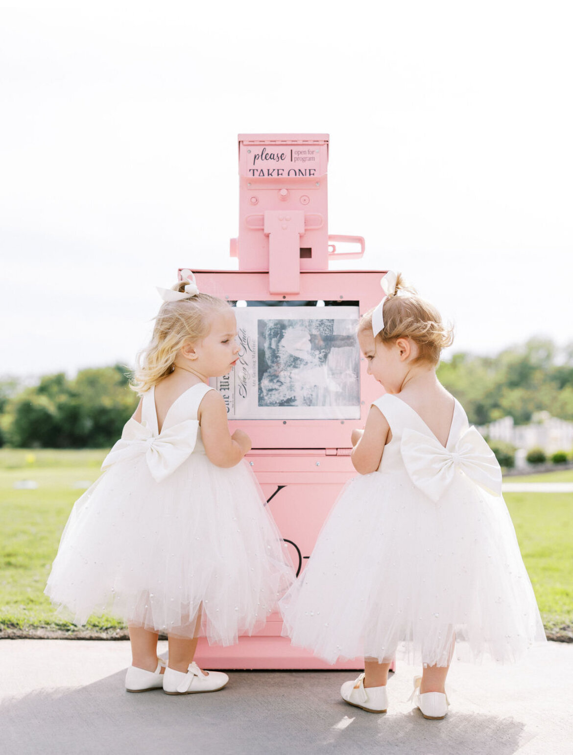 Little girls with pink newspaper stand