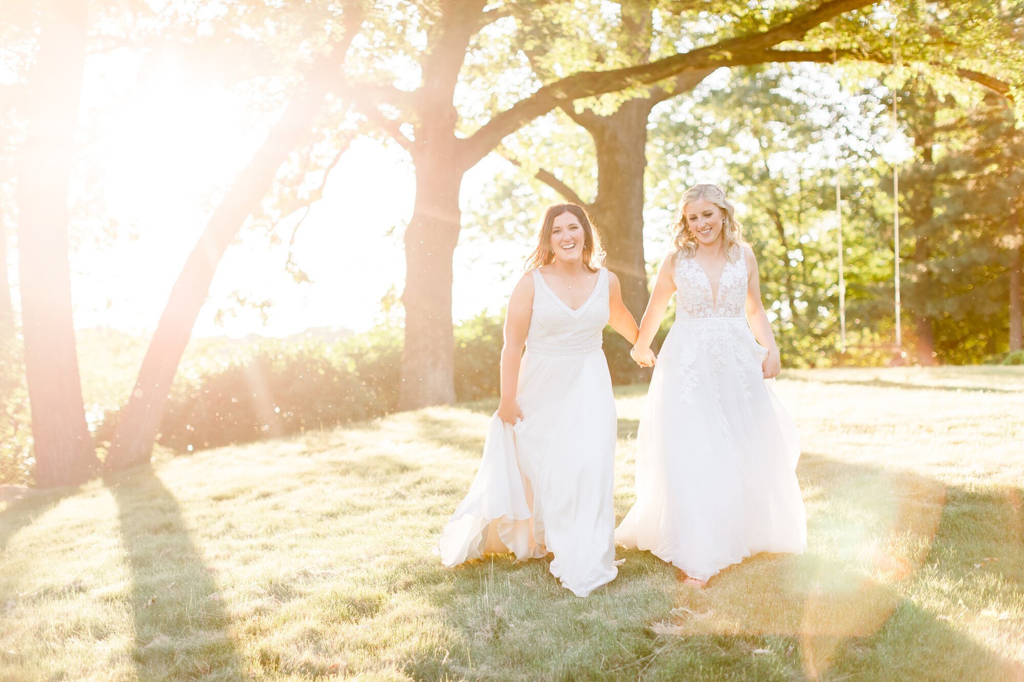 Brides holding hands and walking, taken by minneapolis wedding photographers Kacey Wyrick