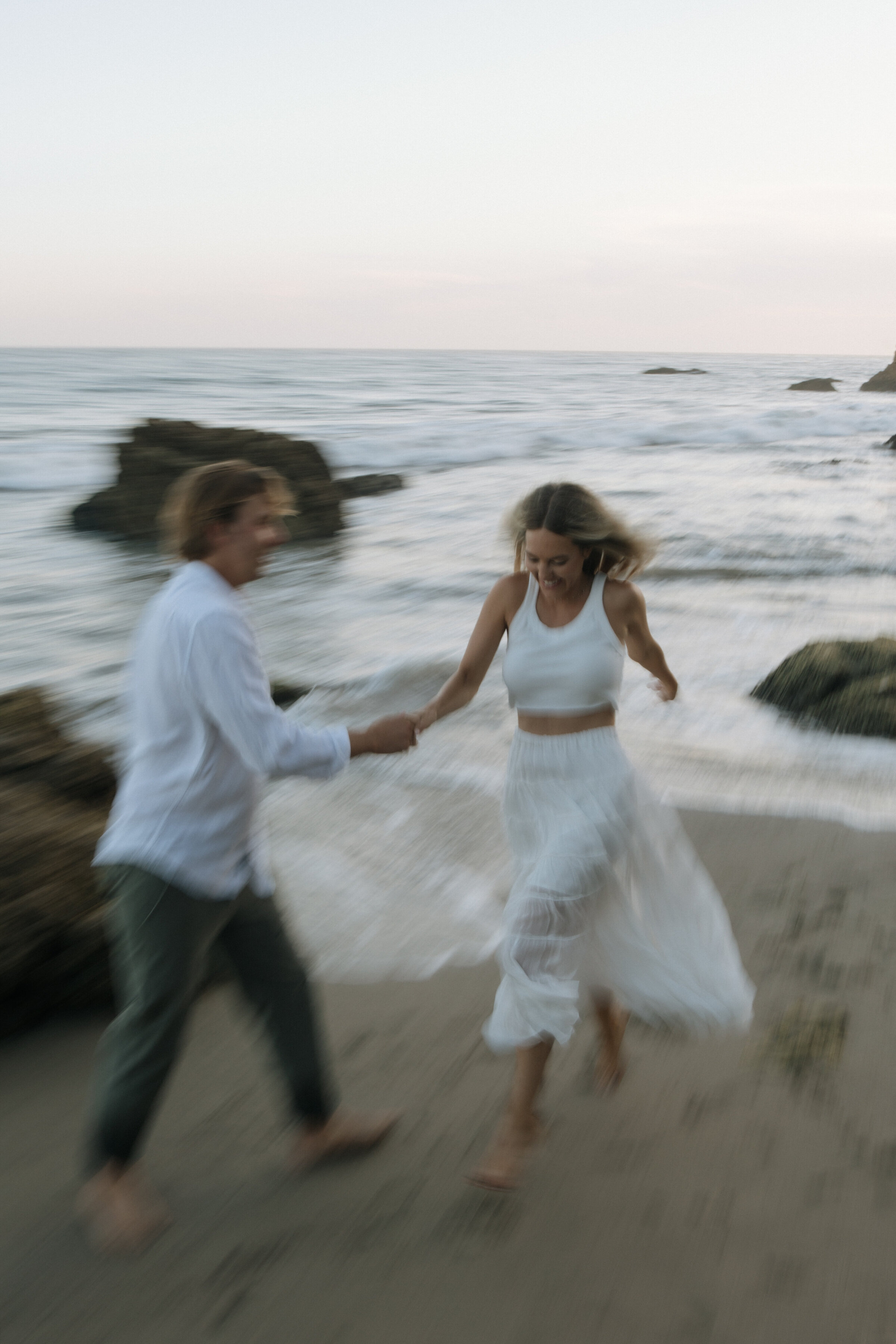 couple running hand and hand on the beach
