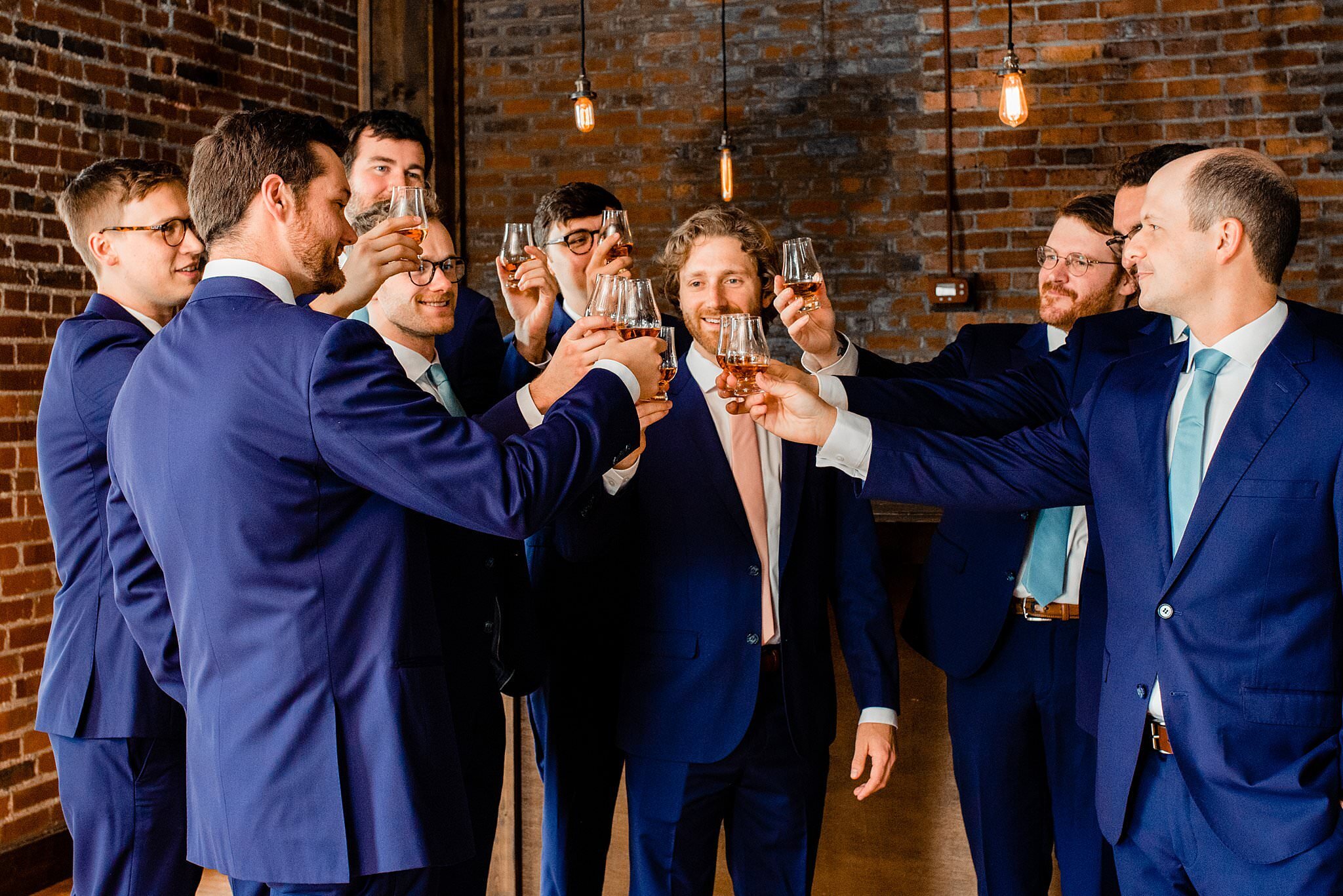 Groom sharing a bourbon toast with his groomsmen in the Cannery ONE bar before the ceremony