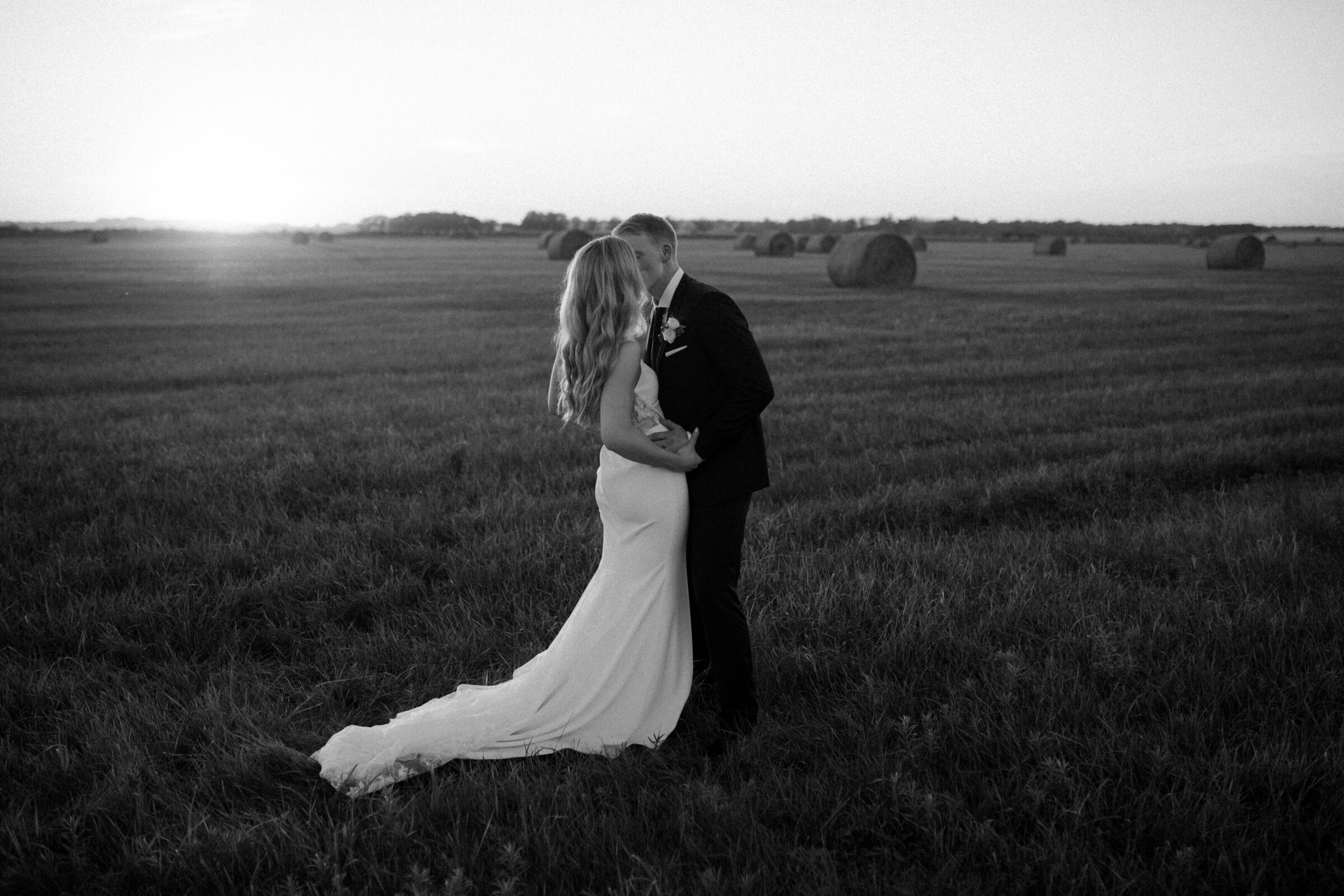 bride and groom  embracing in a field