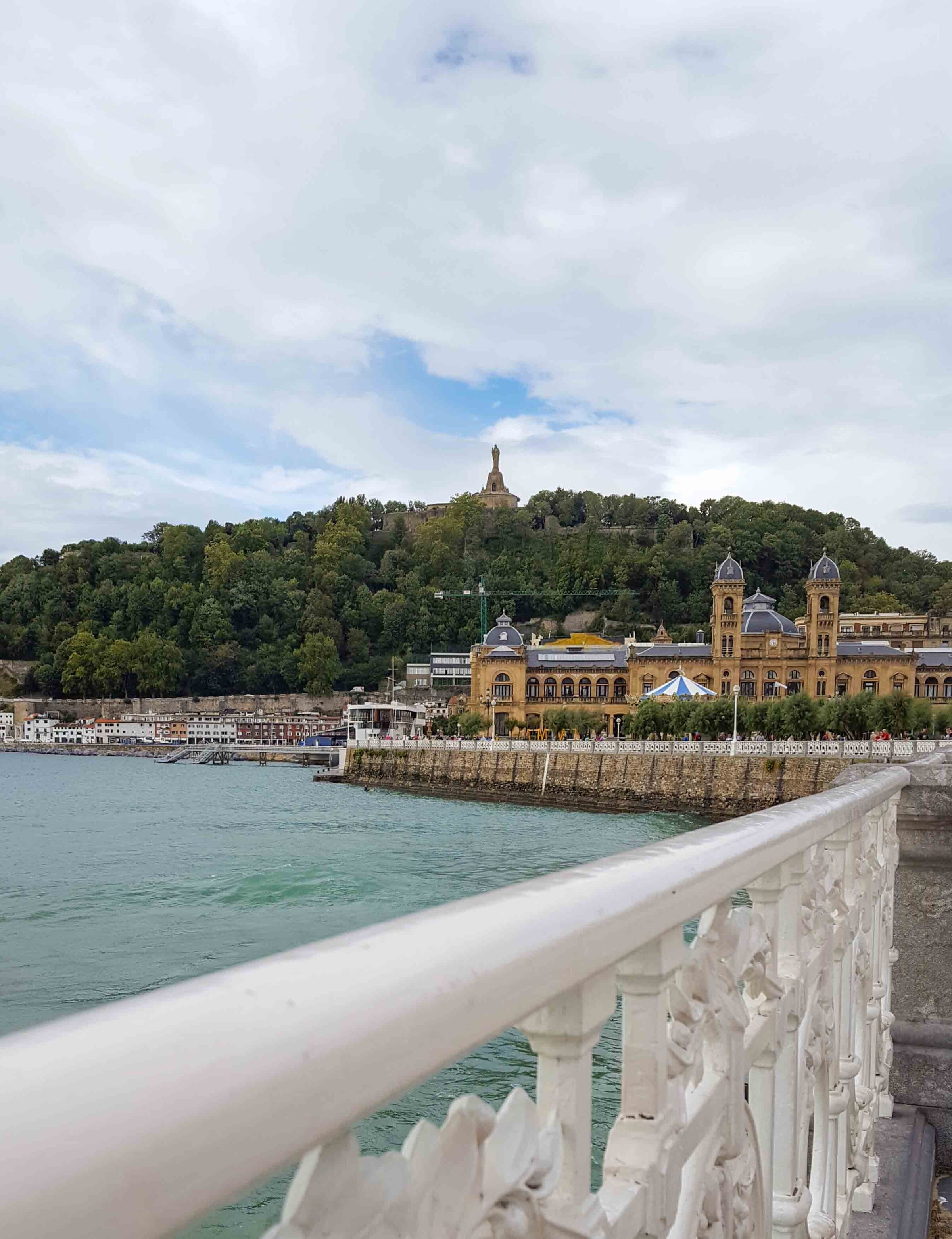 The white railing of La Concha beach leading toward the old town and Monte Urgull in San Sebastian, Spain ©Stephanie Dosch | theViatrix Luxury Travel