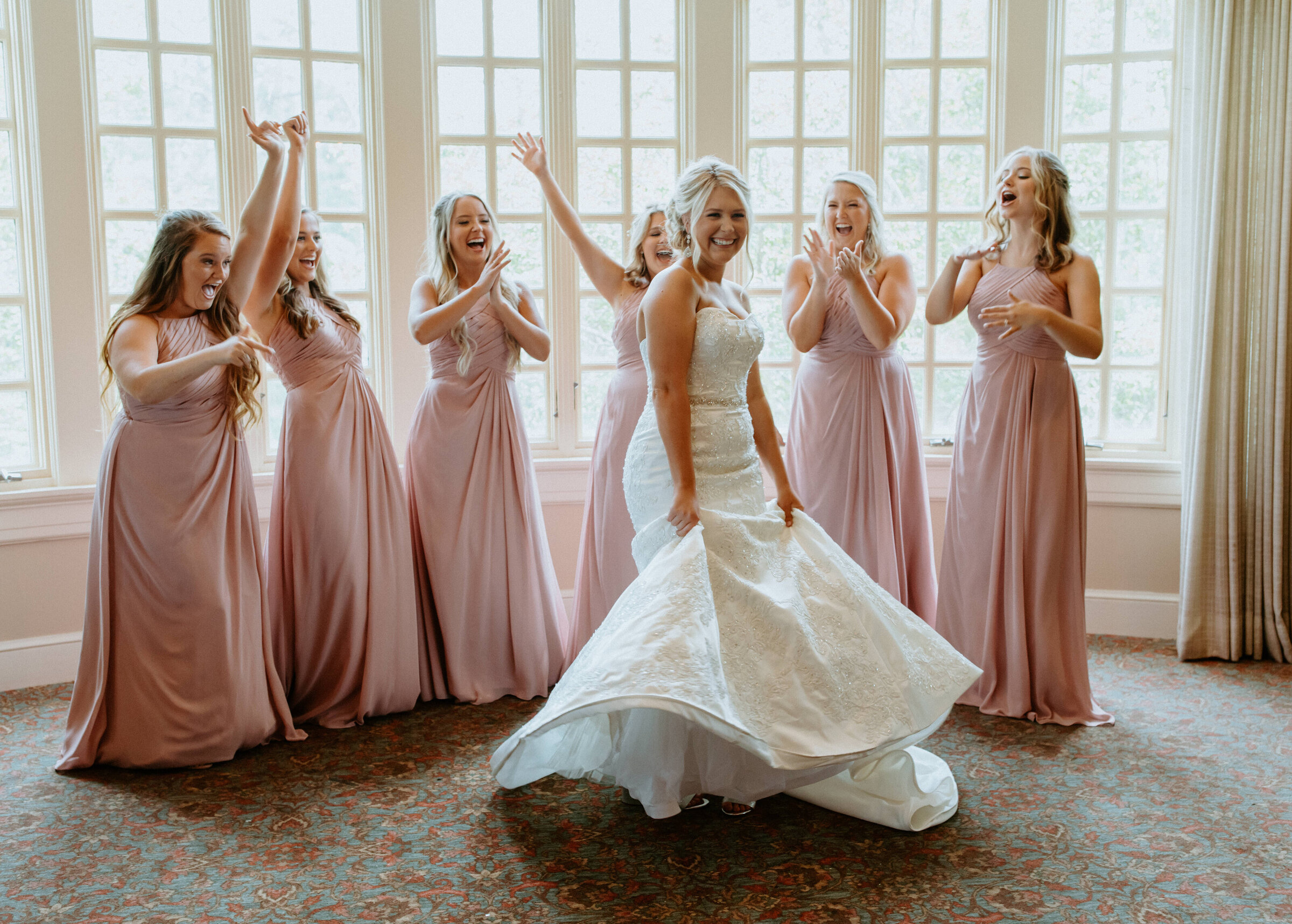 bride laughing with bridesmaids on her wedding day in charleston south carolina