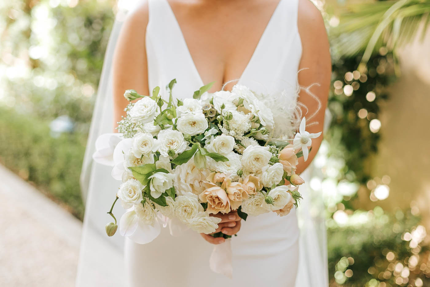 Bride holding white bouquet designed by a san diego wedding florist