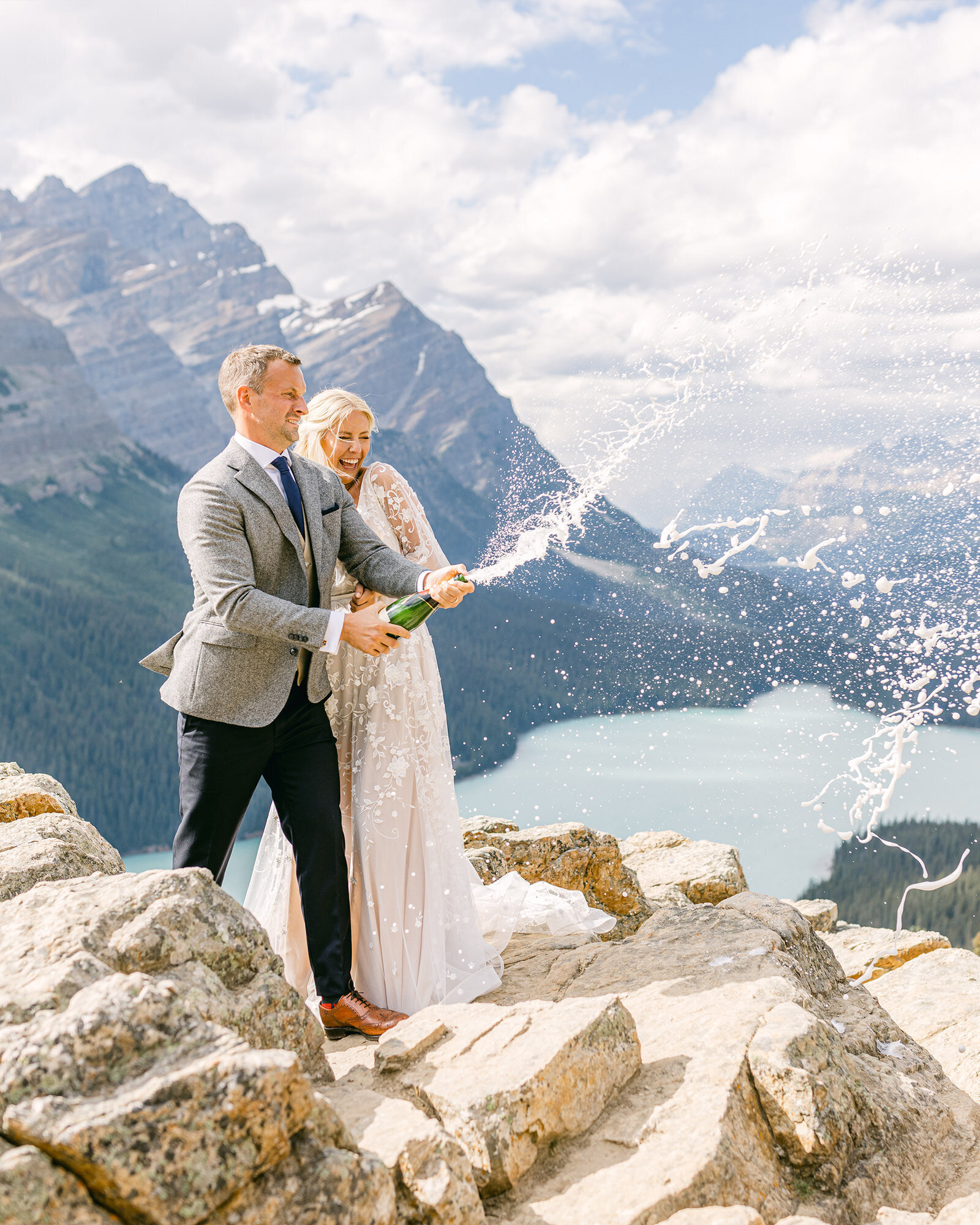 A joyful and celebratory moment as the bride and groom pop a bottle of champagne after their adventure elopement at Peyto Lake in Banff National Park. Surrounded by breathtaking mountain views and the lake’s iconic blue waters, this vibrant and energetic photograph captures the excitement and pure happiness of their unforgettable day.