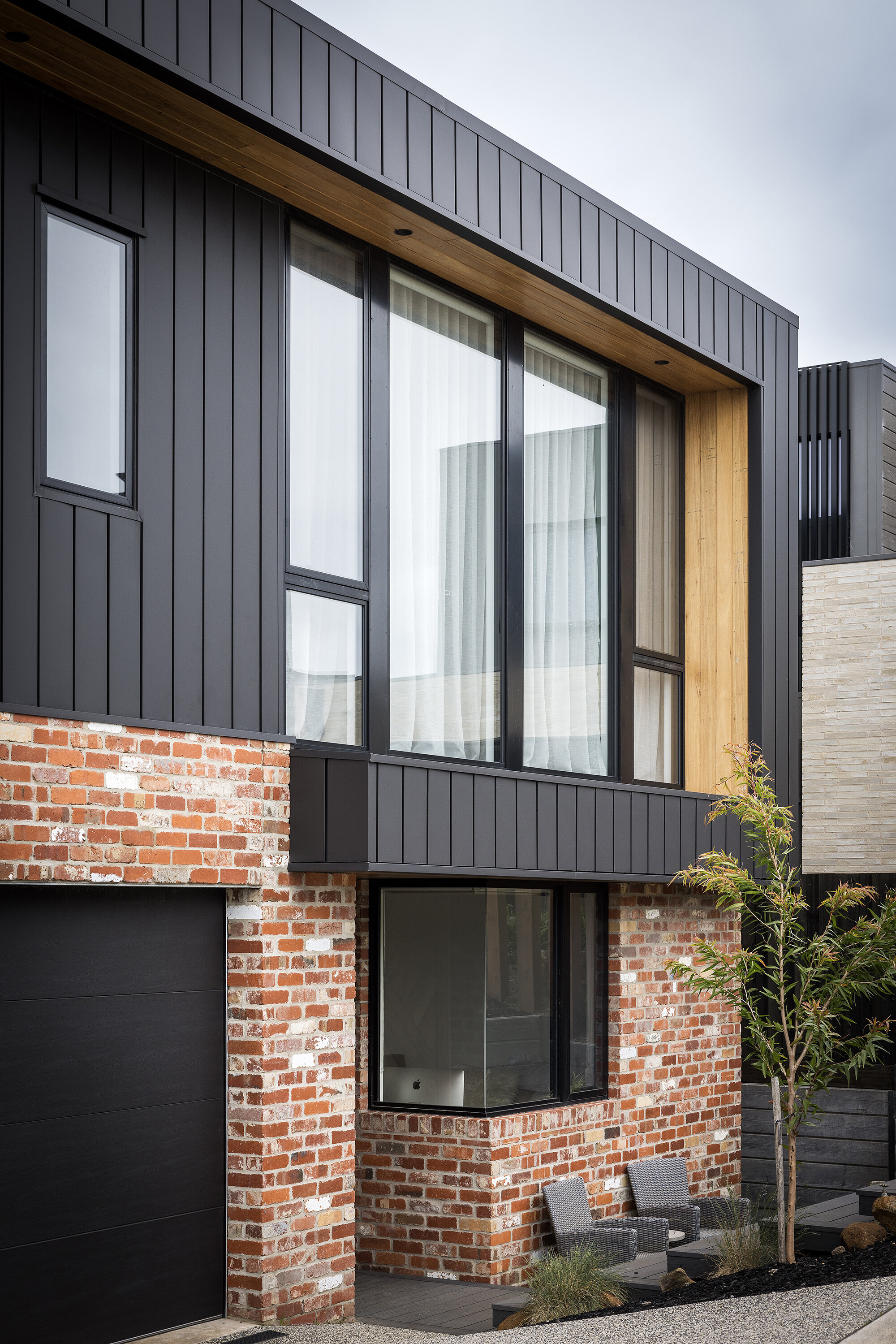 modern home exterior red brick home with black colourbond panels