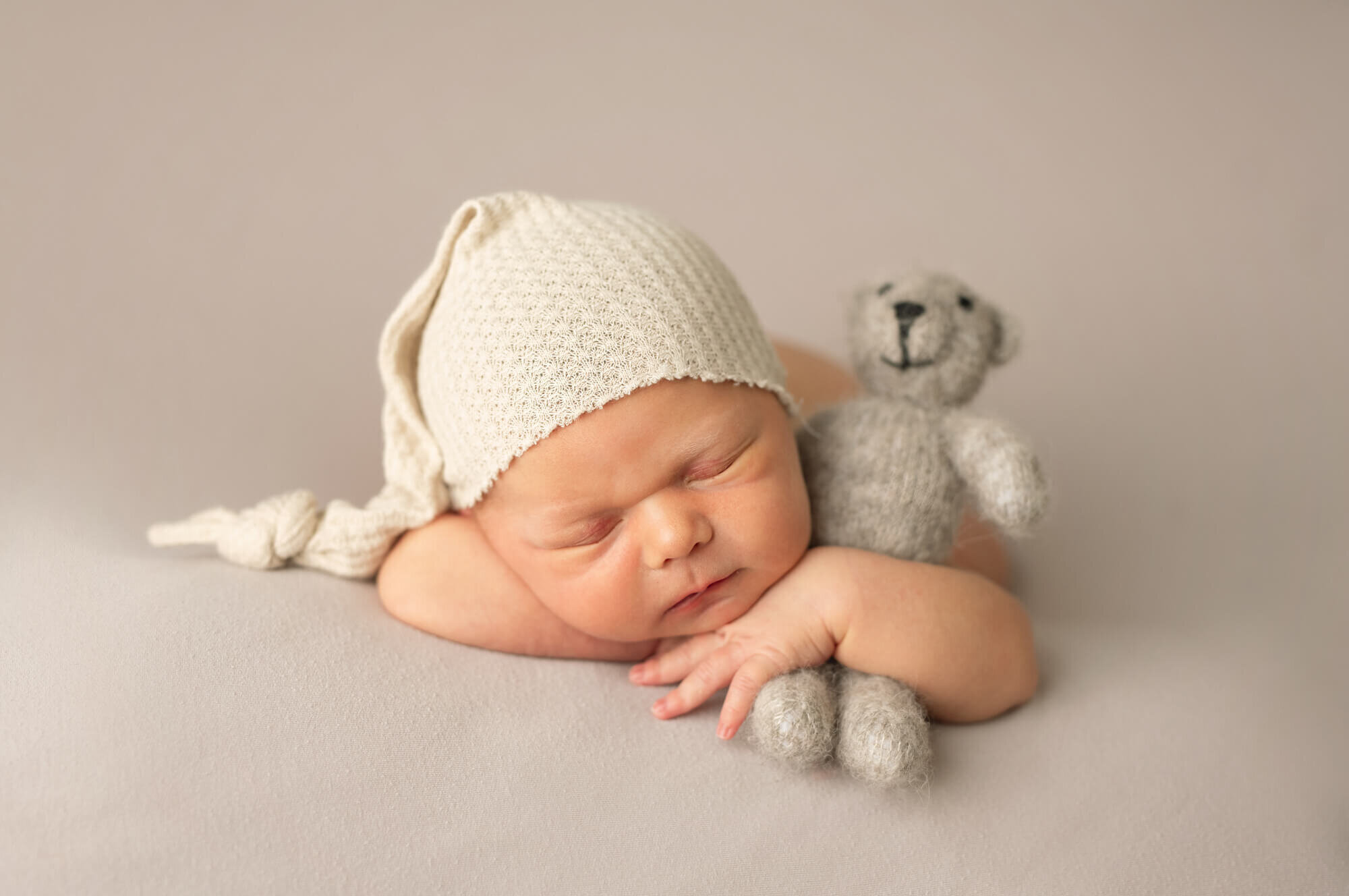 Sleeping baby boy with sleepy cap and teddy bear