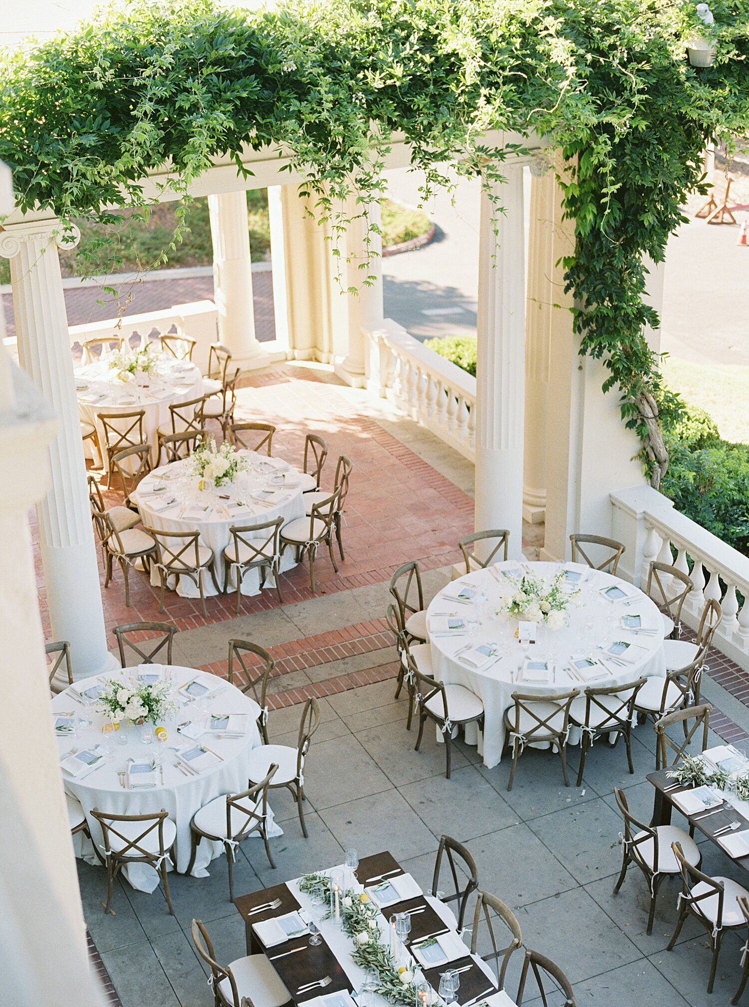 arial photo of round wedding reception tables outdoors on villa patio with greenery in CA
