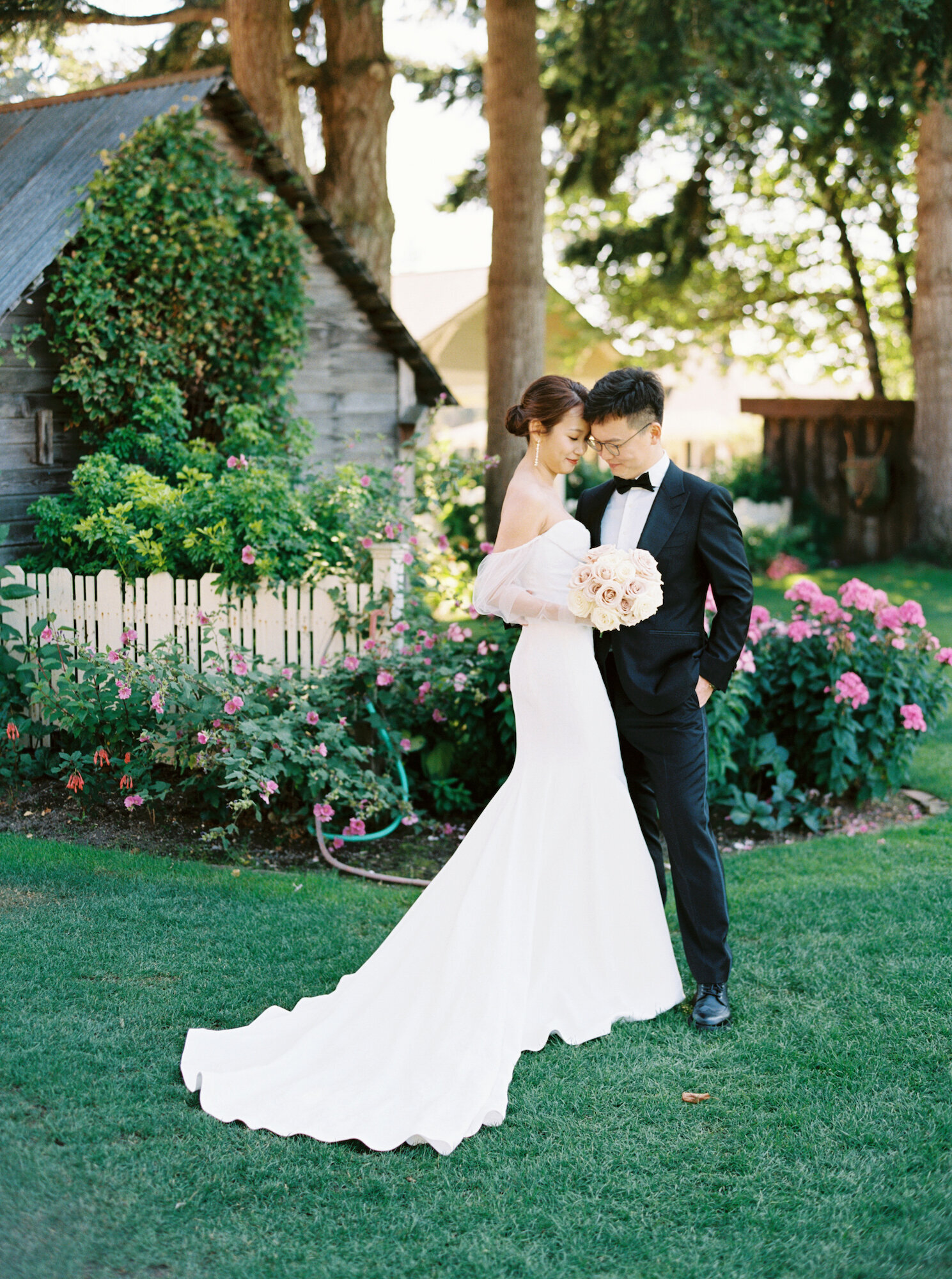 bride and groom foreheads touching in green garden